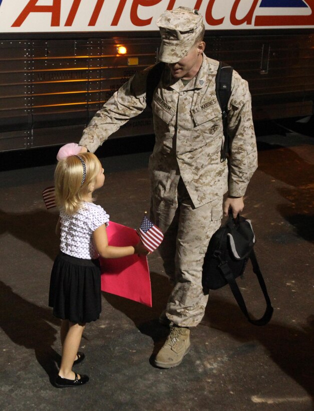 MARINE CORPS BASE CAMP LEJEUNE, N.C.- A young daughter greets her father for the first time in five months as he returns with an advanced party from NATO Training Mission Afghanistan, 3rd Battalion, 10th Marine Regiment, 2nd Marine Division, Sept. 10.  The unit, comprised of Marines from four separate battalions aboard MCB Camp Lejeune was sent home early due to the drawdown of forces in Afghanistan.
