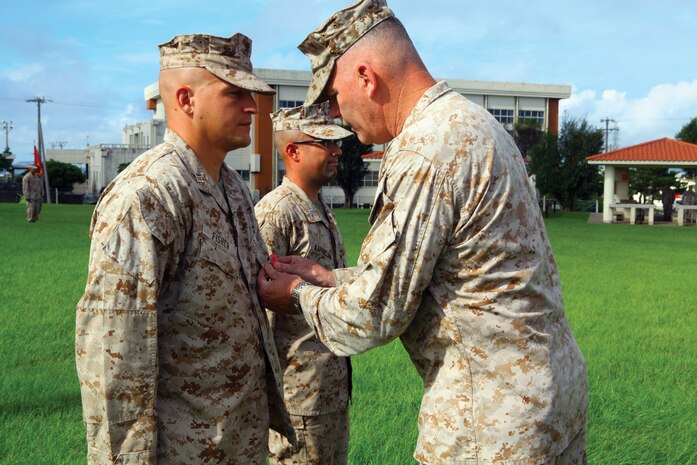 Brig. Gen. Niel E. Nelson pins the Bronze Star onto Capt. Aaron F. Fisher during an award
ceremony at the 9th Engineer Support Battalion physical training field at Camp Hansen Sept.
5. During his seven-month deployment in support of Operation Enduring Freedom, Fisher’s
company played a key role in the completion of more than 45 different engineering projects
including more than 60 kilometers of new route construction. Fisher is the company commander
of Engineer Support Company, 9th ESB, 3rd Marine Logistics Group, III Marine Expeditionary
Force. Nelson is the commanding general of 3rd MLG. Capt. Chistopher M. Kaprielian, standing
beside Fisher, served as the operations officer of 9th ESB