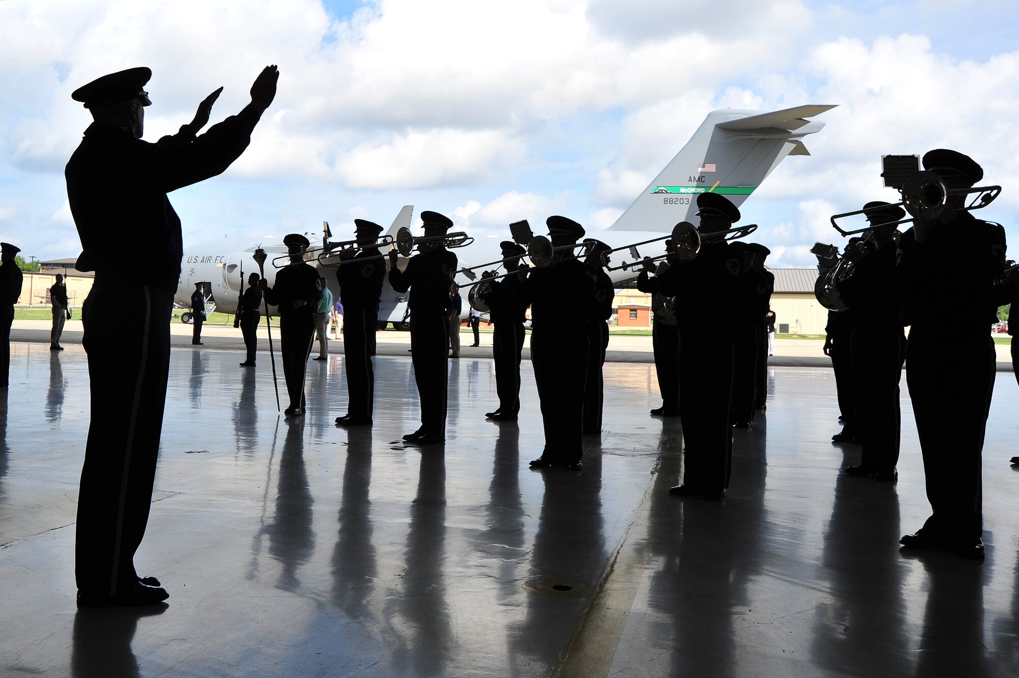 The United States Air Force Band Commander Col. Larry Lang conducts the Ceremonial Brass during a dignified transfer ceremony Sept. 14 at Joint Base Andrews, Md. The ceremony honored U.S. Foreign Service members killed on Sept. 11, 2012, at the U.S. embassy in Benghazi, Libya. President Barack Obama and Secretary of State Hillary Rodham Clinton honored the four American patriots during the ceremony with comments about their military and diplomatic backgrounds and contributions to international diplomacy. (U.S. Air Force photo by Senior Airman Steele C. G. Britton)