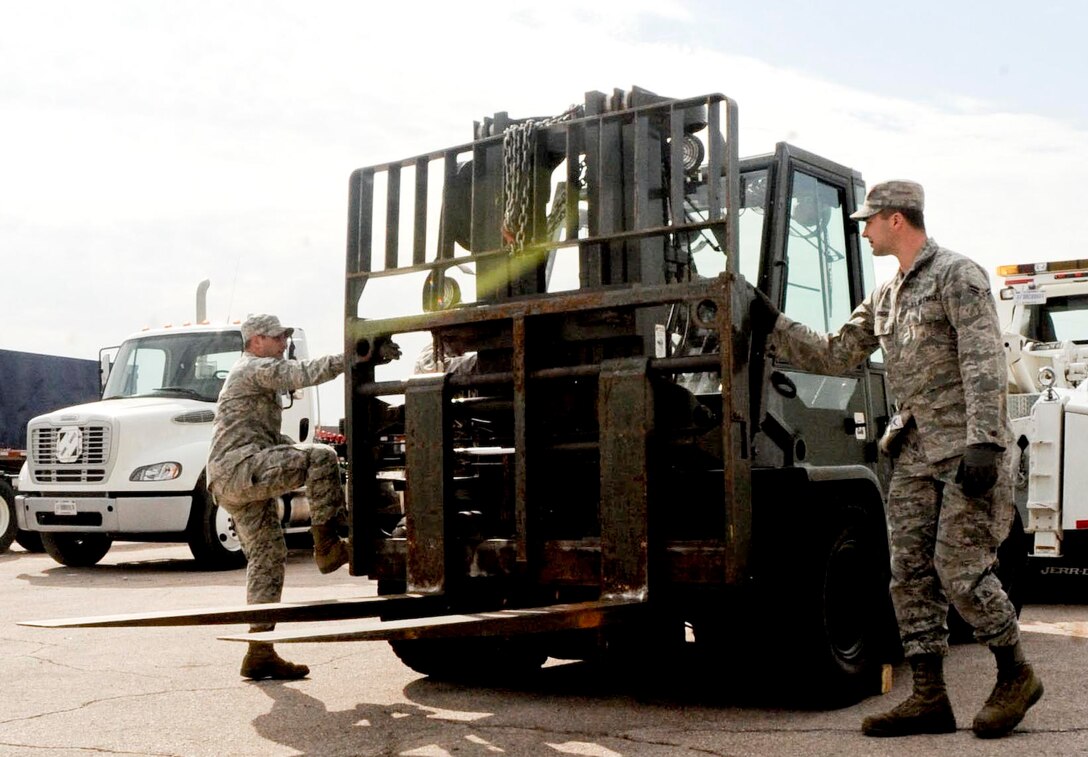 Senior Airman Brandon Everitt (left) and Airman First Class Derek Bright, 28th Logistics Readiness Squadron vehicle operators, prepare to transport a forklift during training at the vehicle maintenance facility at Ellsworth Air Force Base, S.D., Sept. 11, 2012. Vehicle operators must know how to properly transport heavy machinery to and from different locations to help prevent injuries to people and potential damage to equipment while ensuring the mission is accomplished. (U.S. Air Force photo by Airman 1st Class Anania Tekurio/Released)