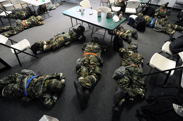 Exercise participants stay low under "Alarm Red, Mission-Oriented Protective Posture 4" conditions during an Operational Readiness Exercise scenario Sept. 13 at Joint Base Pearl Harbor-Hickam, Hawaii. The exercise's participants were tested on their ability to properly react to a broad range of scenarios and environmental conditions. (U.S. Air Force photo by Staff Sgt. Nathan Allen) 