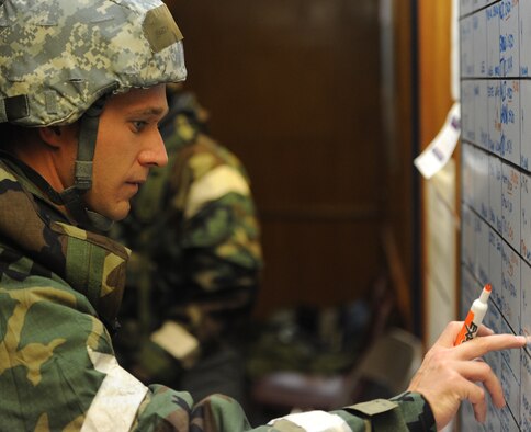 Capt. Bobby Scott, 535th Airlift Squadron operations controller, reviews an information board Sept. 12 during an Operational Readiness Exercise scenario on the 15th Wing flightline at Joint Base Pearl Harbor-Hickam, Hawaii. The exercise's participants were tested on their ability to properly react to a broad range of scenarios and environmental conditions. (U.S. Air Force photo by Staff Sgt. Nathan Allen) 