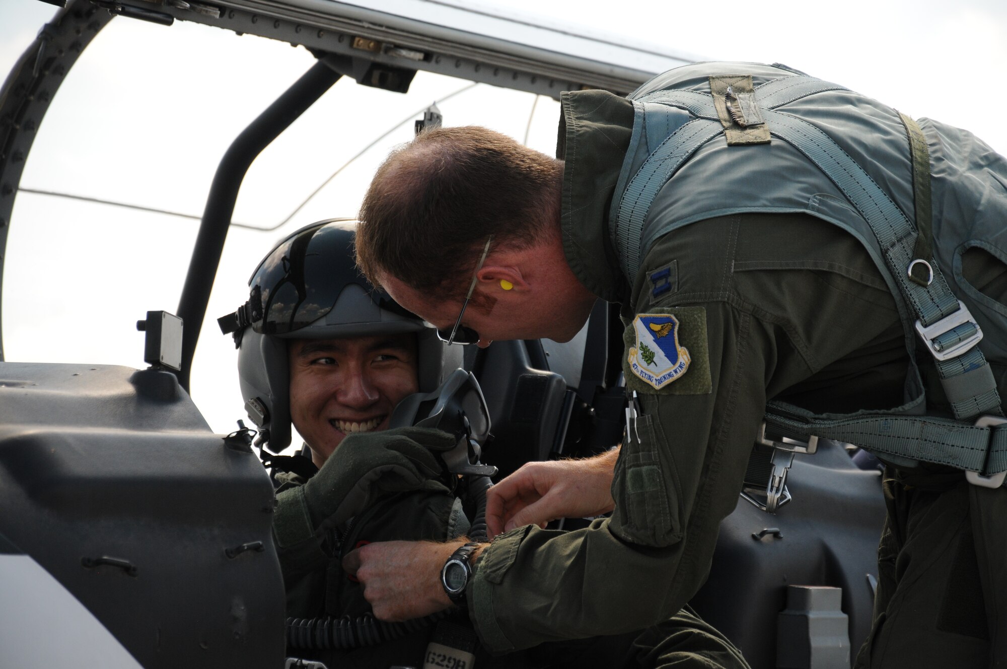 Just prior to 2nd Lt. Jun Liang Tan, 47th Student Squadron, making his first solo flight in a T-6 Texan II, his instructor pilot, Capt. Brian Staniszewski, 434th Flying Training Squadron, replaces Tan’s name patch with his own.  The gesture is a long-standing tradition of military aviation, symbolizing that the instructor pilot is willing to trust the student with his own reputation.  (U.S. Air Force photo/2nd Lt. Daniel Brand)