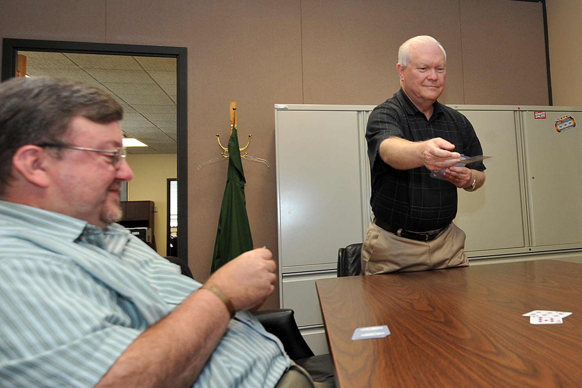 Pierre Flatowicz throws his card into bid while Bill Tiarks, both with the 55th Force Support Squadron, learn the game of bridge inside Building C on Offutt Air Force Base, Neb., Sept. 13. Flatowicz has won more than 145 Regional tournaments, 75 Sectional tournaments and has come in the overalls 10 times in national tournaments.  (U.S. Air Force photo by Charles Haymond/Released)