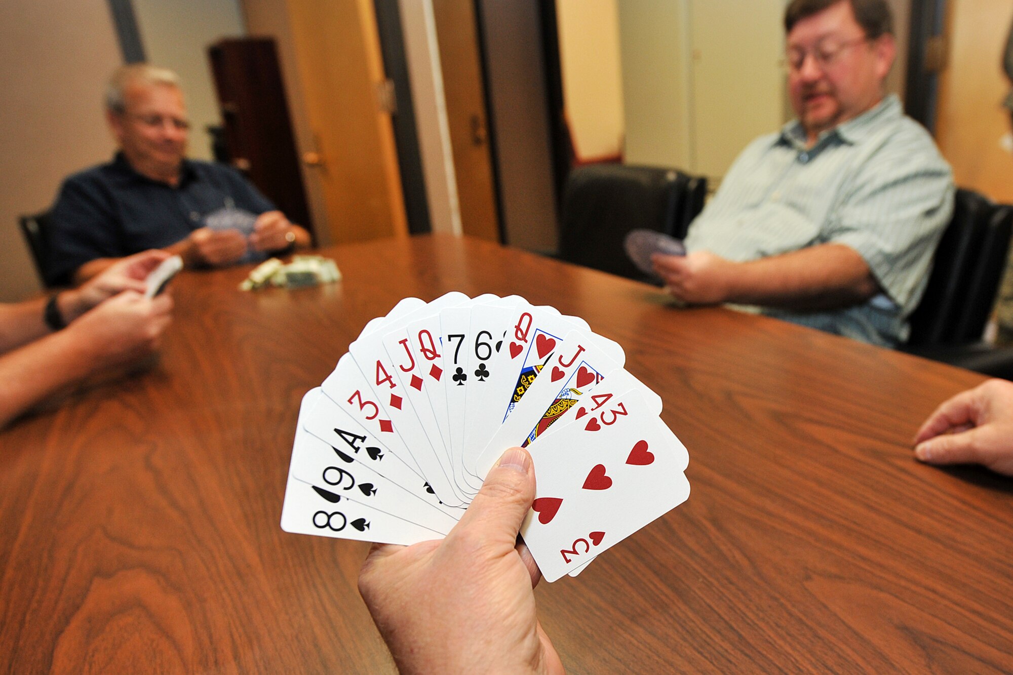 U.S. Air Force civilian Pierre Flatowicz, with 55th Force Support Squadron, holds up his cards before playing a bridge game inside the Building C on Offutt Air Force Base, Neb., Sept. 13. In the game of bridge, Flatowicz is a platinum life master which is the second highest rank in the American Contract Bridge League. (U.S. Air Force photo by Charles Haymond/Released)