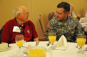 Maj. Gen. Mark MacCarley, Deputy Chief of Staff, U.S. Army Training and Doctrine Command, meets with Gordon Bates, a World War II veteran who served with the 503rd Parachute Regimental Combat Team, during the team's reunion breakfast the morning of Sept. 13, 2012 at Richmond, Va. The reunion included a day trip to Washington D.C. to visit the Tomb of the Unknown Soldier, and the World War II and Korean War Veterans Memorials. Members of the Honor flight Historic Triangle Virginia, a non-profit organization, were the veteran's escorts for the day. (U.S. Army photo by Sgt. 1st Class Kelly Jo Bridgwater/Released)