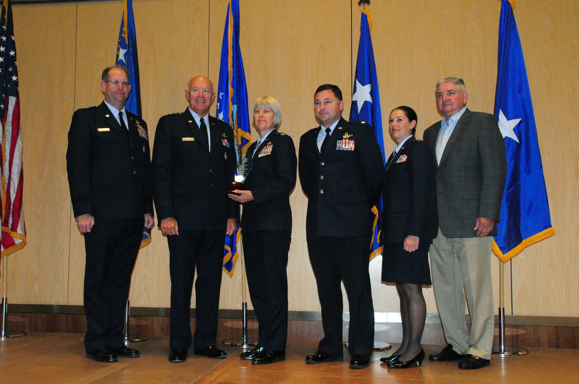 Brig. Gen. William Burks, Vice Chairman of the National Guard Association of the United States (NGAUS), Lt. Gen. Harry M. Wyatt III, Director, Air National Guard and Gen. (Ret.) Ron Fogleman, former Chief of Staff, Air National Guard (far right) present the Winston P. Wilson Trophy to 148th Fighter Wing members, Col. Penny Dieryck, Lt. Col. Guy Schaumburg and Capt. Gina Keppeler on September 12, 2012 during the NGAUS conference in Reno, Nev.  The Winston P. Wilson Trophy is presented to the most outstanding Air National Guard flying unit equipped with Fighter or Reconnaissance aircraft.  (National Guard photo by 1st Lt. Jodi Kiminski)