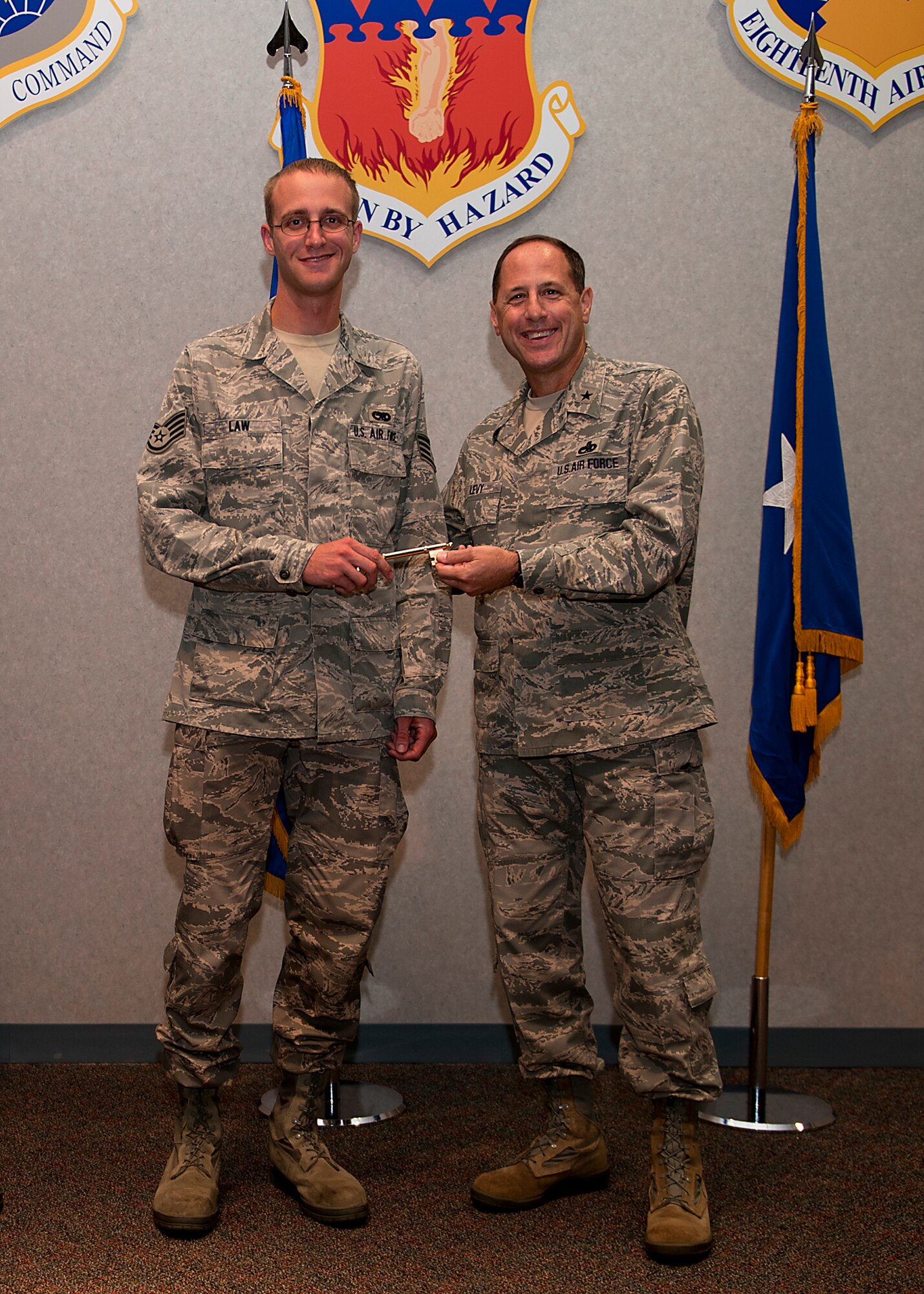 U.S. Air Force Brig. Gen. Lee Levy, Headquarters Air Mobility Command director of logistics, left, presents Staff Sgt. Steven Law, 317th Aircraft Maintenance Squadron, with the honorary key to the newest C-130J Super Hercules Sept. 13, 2012, at Dyess Air Force Base, Texas. This is the 23rd C-130J of 28 to be delivered to Dyess by 2013, replacing the current legacy fleet of C-130H models. Once the final aircraft is delivered, Dyess will be home to the largest C-130J fleet in the world. (U.S. Air Force photo by Airman 1st Class Damon Kasberg/ Released)