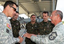 Senior Master Sgt. Brian McNabb, left, maintenance operation center senior controller, 175th Maintenance Operation Flight, discusses the A-10C with Maj. Kirk Pietsch, Maryland National Guard, Bosnians Maj. Enes Dzinic, Capt. Zeljko Krajina and Maj. Slobodan Simic. The group of Bosnian public affairs officers toured Warfield Air National Guard Base in Baltimore, Md. on Friday, September 14, 2012. Pietsch hold a 30mm round that is fired from the A-10C.  (National Guard photo by Tech. Sgt. David Speicher)