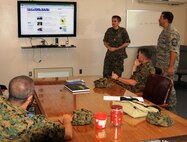 Major Slobodan Simic, center, and Senior Master Sgt. Ed Bard discuss a Bosnia-Herzegovina military web page, Friday, September 14, 2012. Simic is part of group of Bosnian public affairs officers touring Warfield Air National Guard Base in Baltimore, Md. Bard, 175th Wing Public Affairs superintendent, explained how the 175th Wing gets their message out to the public. (National Guard photo by Tech. Sgt. David Speicher)
