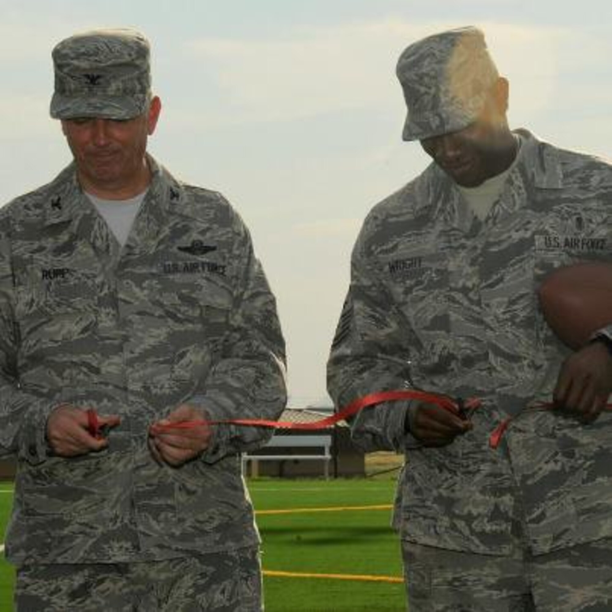 Col. Ricky Rupp, 22nd Air Refueling Wing commander, and Chief Master Sgt. Kaleth Wright, 22nd ARW command chief, cut the ribbon at the grand opening of the football field Sept. 12, 2012, McConnell Air Force Base, Kan. Following the ribbon-cutting ceremony, the field was used for the first intramural football game of 2012.  The field was one of many quality-of-life improvements made at McConnell during 2012.  (U.S. Air Force photo/Airman 1st Class Jose L. Leon)
