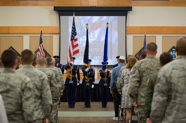 Members of Team Malmstrom stand at attention during the presentation of the colors by Malmstrom’s Honor Guard during the remembrance ceremony on Sept. 11.  The ceremony included words of remembrance read by Col. David Bliesner, 341st Maintenance Group commander, and the singing of “God Bless America” by the Malmstrom Men’s Ensemble. (U.S. Air Force photo/Beau Wade)