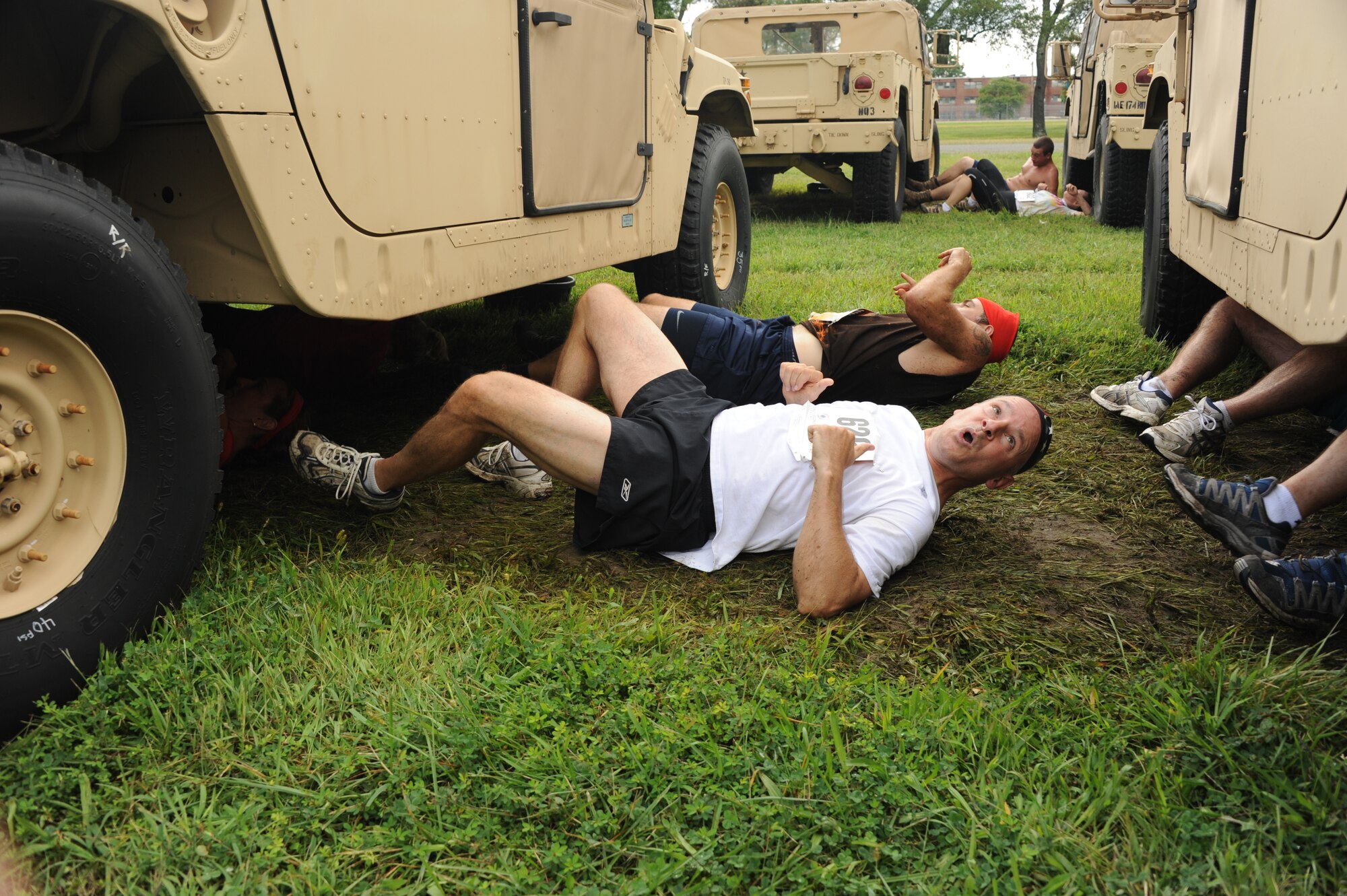 Mud run participants shimmy two-by-two under Humvees Sept. 8 at the "Humvee Crawl" obstacle during the Joint Base McGuire-Dix-Lakehurst "Beast of the East" Mud Run. Participants came from all over the Northeast to try their hands at the 10K mud run through the installation. (U.S. Air Force photo by Ryan Throneberry/Released)

