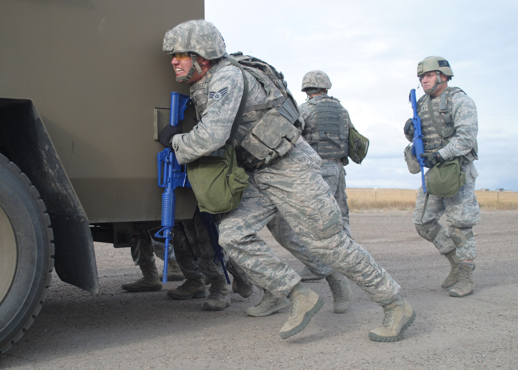 Senior Airman Collin Kleckley, 341st Security Forces Squadron member, works with the rest of his team to push a Bearcat while 1st Lt. Michael Bruton, 341st Security Forces Group Tactical Response Force officer in charge, far right, performs security behind the vehicle. The Bearcat push was one of five stations the team had to complete during a mental and physical challenge at the Warrior Launch Facility in preparation for the Global Strike Challenge. (U.S. Air Force photo/Airman 1st Class Katrina Heikkinen)