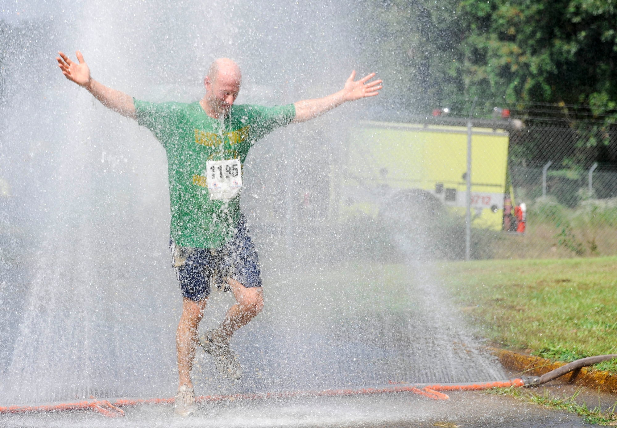 A mud run participant rinses off as he reaches the final leg of the Joint Base McGuire-Dix-Lakehurst "Beast of the East" Mud Run Sept. 8 here. This sprinkler, along with a shower truck, allowed runners to clean off the mud before returning home after their adventure. (U.S. Air Force photo by 2nd Lt. David J. Murphy/Released)