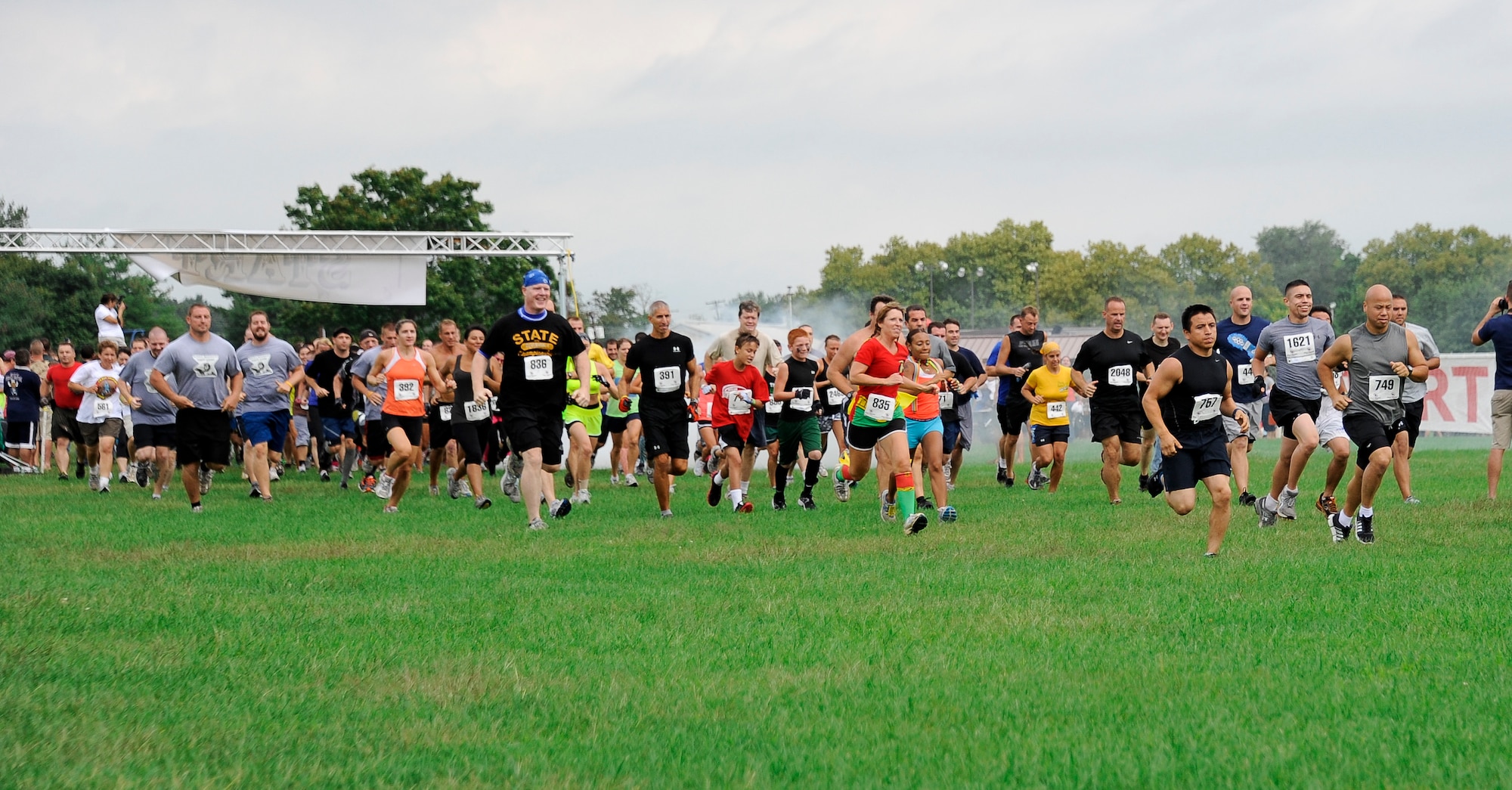 Runners dart off the starting line Sept. 8 at the Joint Base McGuire-Dix-Lakehurst "Beast of the East" Mud Run at Doughboy field. Runners dressed in a variety of costumes for the event, some even had teams dedicated to a particular theme. (U.S. Air Force photo by 2nd Lt. David J. Murphy/Released)