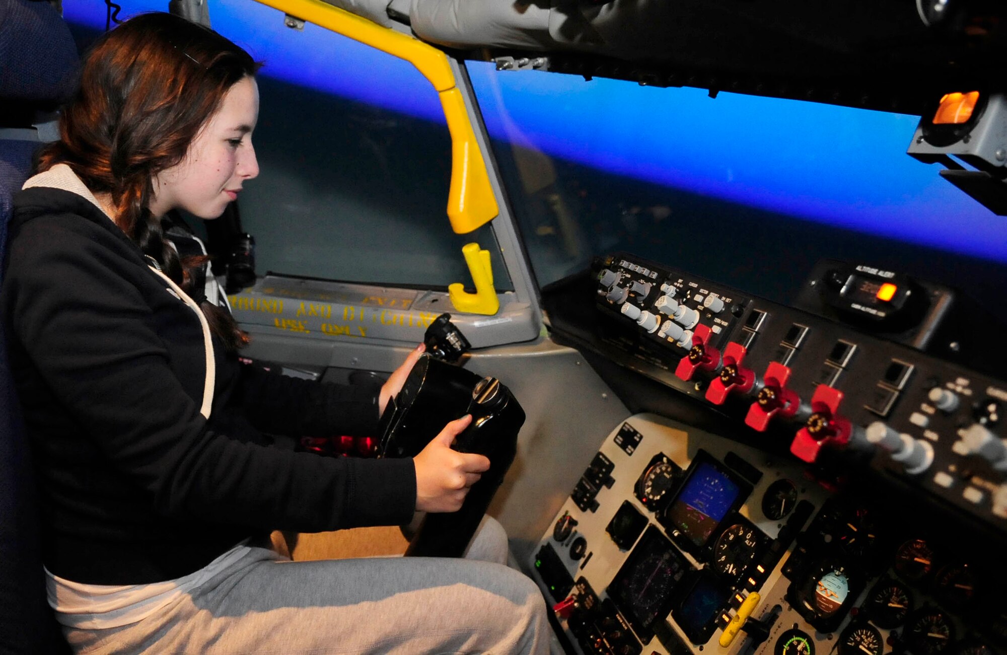 RAF MILDENHALL, England – Cara Thompson, the daughter of Khris Thompson, a former member of the 351st Air Refueling Squadron, flies a flight simulator during a base tour, Sept. 14 2012, at RAF Mildenhall. The former members of the squadron and their families toured the base to celebrate their 20 year reunion. (U.S. Air Force photo/Senior Airman Ethan Morgan)         