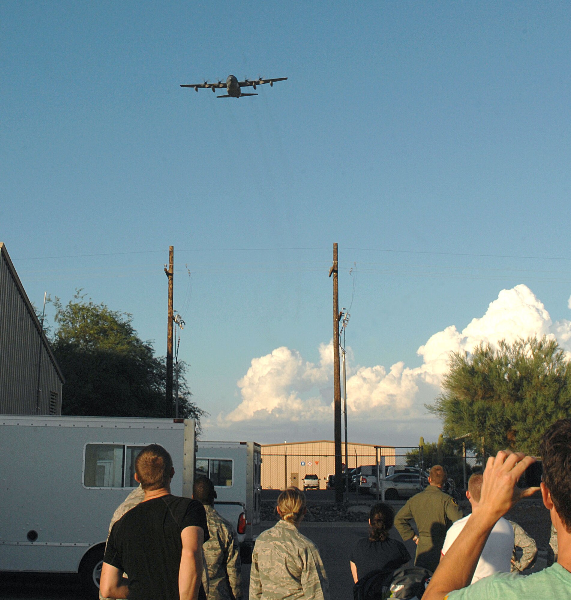 A U.S. Air Force HC-130P flies over squadron family members that have gathered on the flightline for the final landing of the aircraft at Davis-Monthan Air Force Base, Ariz., Sept. 12, 2012. This was the last flight of any HC-130P aircraft on D-M. The new aircraft, the HC-130J, is scheduled to start flying in October. (U.S. Air Force photo by Airman 1st Class Saphfire Cook) 