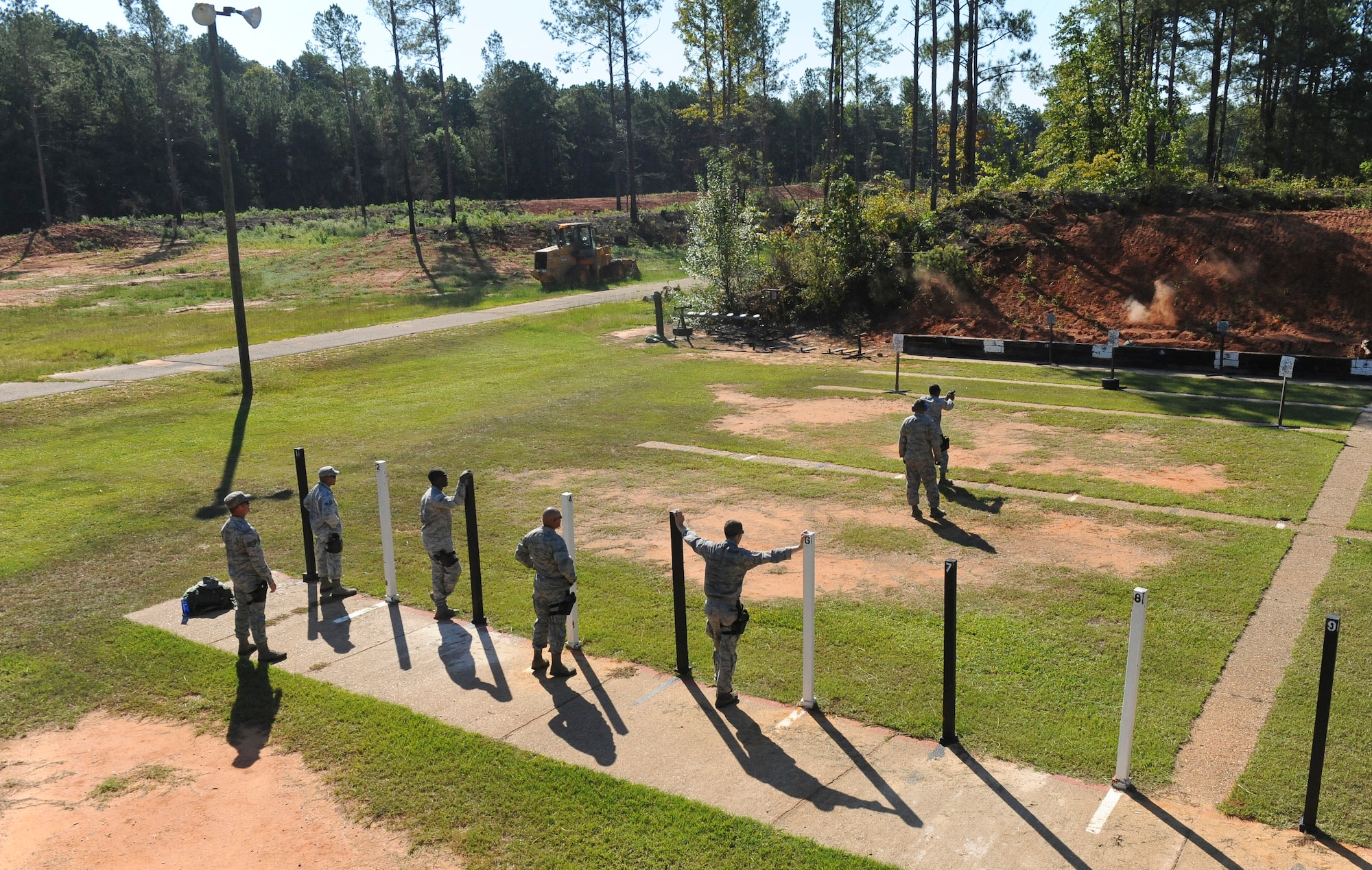 Airmen from the 2nd Security Forces Squadron watch as a fellow 2 SFS Airman fires an M-9 pistol at the Bossier Parish Sheriff?s Office pistol range in Plain Dealing, La., Sept. 11. The Airmen spent the morning firing the M-9 at various targets to prepare for the 2012 annual Global Strike Challenge. (U.S. Air Force photo/Senior Airman Micaiah Anthony)(RELEASED)