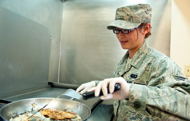 Senior Airman Vang Yang, 319th Missile Squadron missile chef, cooks chicken and onions to be used in different lunch entrees Aug. 23 in the Delta-01 Missile Alert Facility kitchen. (U.S. Air Force photo by Airman 1st Class Jason Wiese)