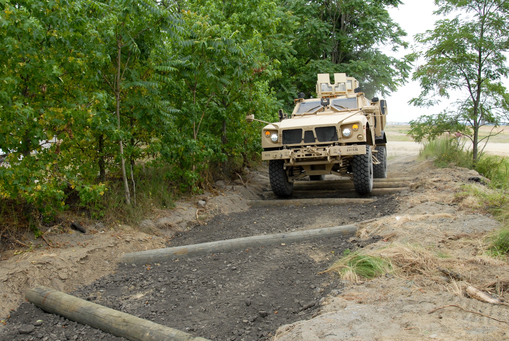 A master driver in the 174th Infantry Brigade carefully steers a Mine Resistant Ambush Protected vehicle over the uneven log obstacle at the revamped driver's training course, July 13 here. The obstacle is meant to enhance a driver's understanding of the handling characteristics of the MRAP, resulting in greater confidence and a decrease in rollover accidents. (U.S. Army photo by Staff Sgt. Nicole Dykstra/Released)