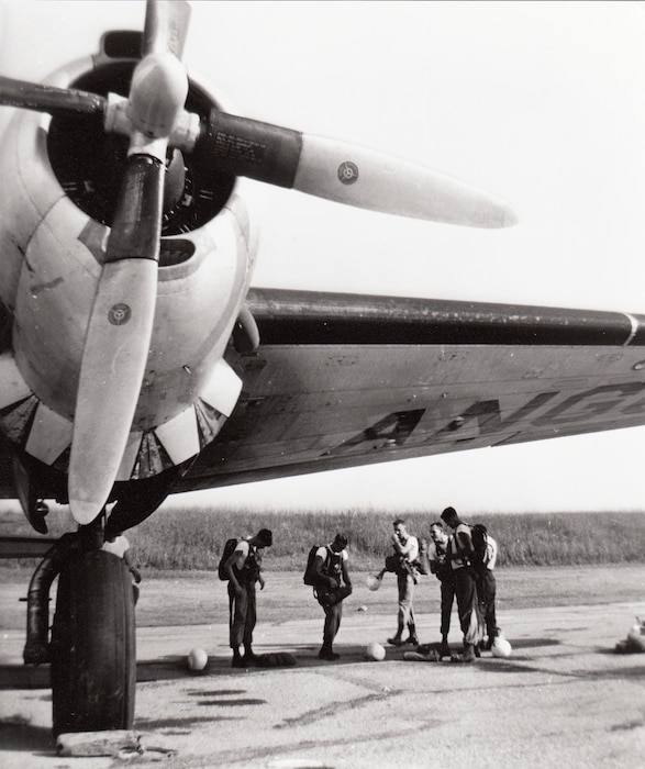 Army paratroopers don their parachutes by a C-47 of the 135th Air Commando Group, Maryland Air National Guard during annual active-duty training at Sewart Air Force Base, Tennessee, 1952.  (Captain Stanley Howard)