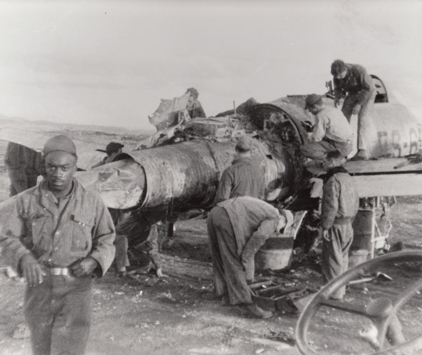 Airmen of the Texas Air National Guard work with a wrecked F-84 fighter, Korea.