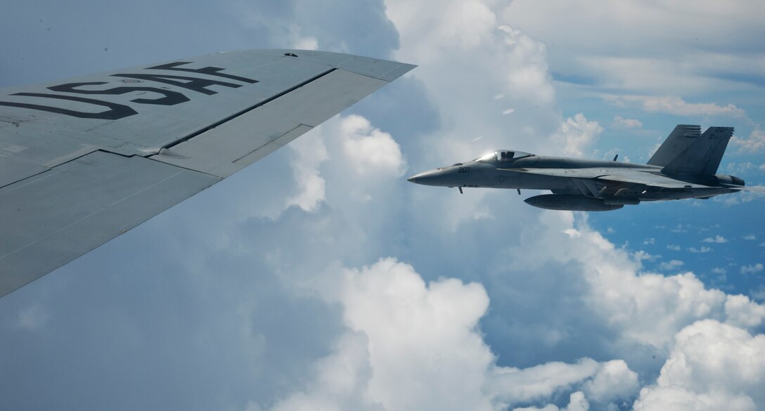 Andersen AFB, Guam --A U.S. Marine Corps F/A-18 Hornet from the Marine Aircraft Group 12 at Marine Corps Air Station Iwakuni, Japan flies beside a KC-135 Stratotanker from the 97th Air Mobility Wing Altus Air Force Base, Okla. after refueling over the Pacific ocean Sept. 14, 2012. VS12 is a U.S.-only exercise with a focus on integration of joint training among U.S. forces in relation to current operational plans. This training enables real-world proficiency in sustaining joint forces through detecting, locating, tracking and engaging units at sea, in the air, on land and cyberspace in response to a range of mission areas.  (U.S. Air Force photo by Staff Sgt. Alexandre Montes/RELEASED)