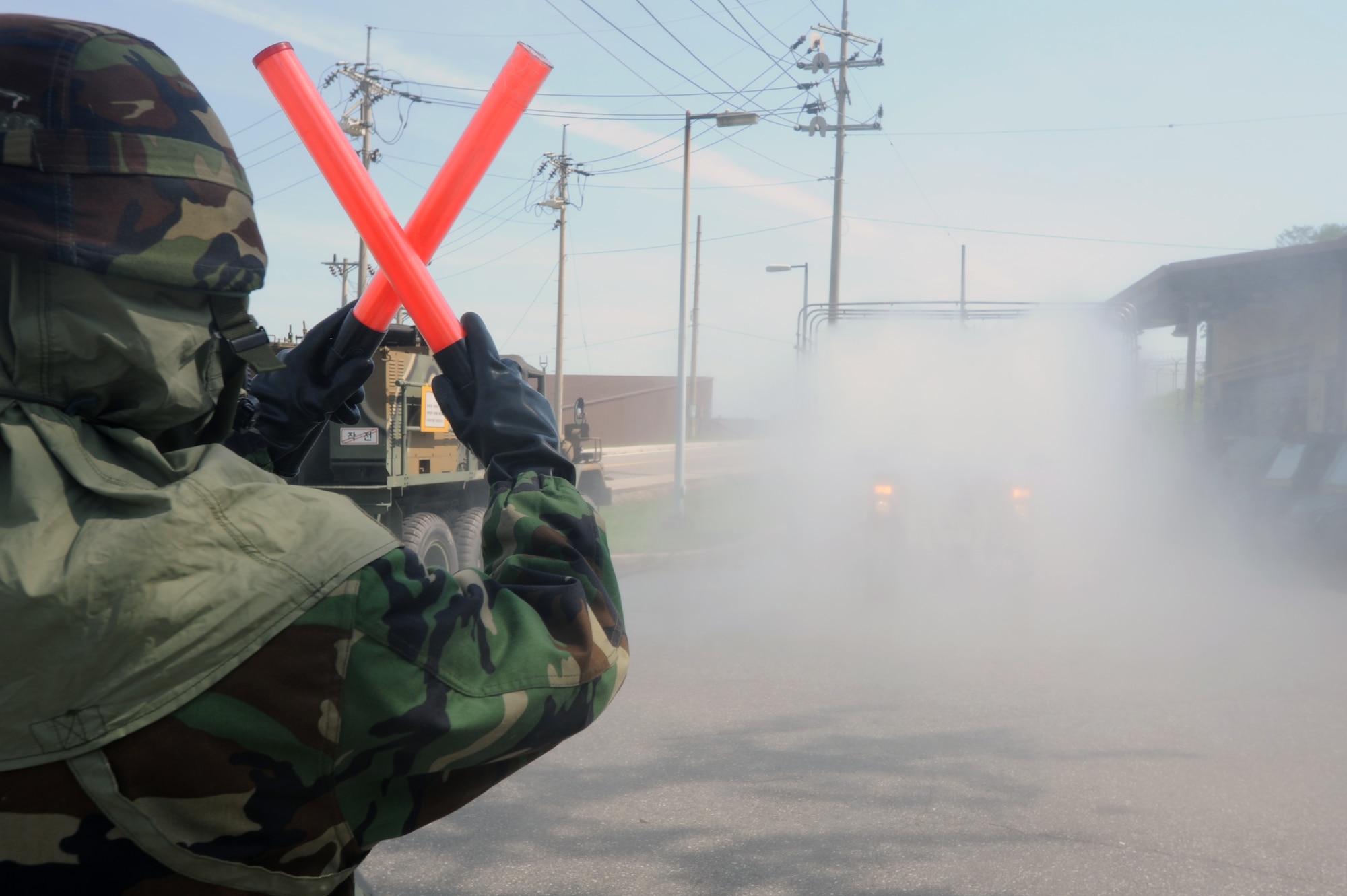 A Republic of Korea Air Force chemical warfare member signals a vehicle to stop for simulated decontamination at Osan Air Base, Republic of Korea, Sept. 7, 2012. U.S. Air Force and ROKAF members participated in a combined exercise to familiarize the units with chemical, biological, radiological, nuclear and high yield attack response procedures. (U.S. Air Force photo/Airman 1st Class Alexis Siekert)


