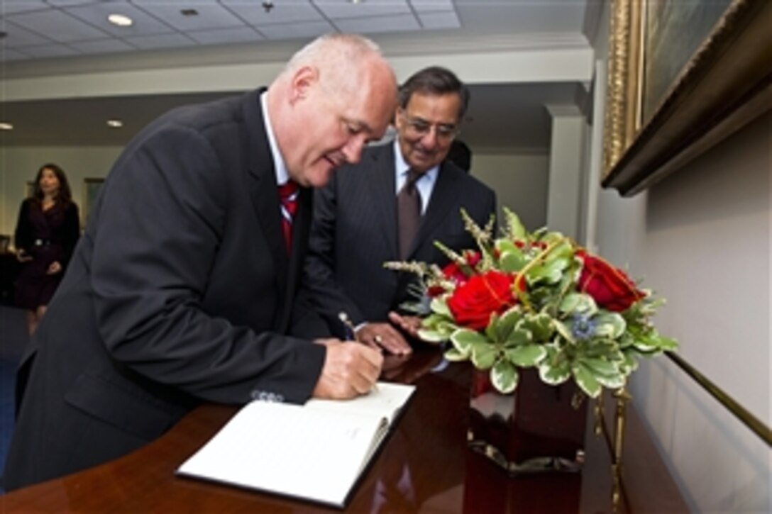 Defense Secretary Leon E. Panetta looks on as Hungarian Defense Minister Csaba Hende signs the guest book at the Pentagon, Sept. 14, 2012.