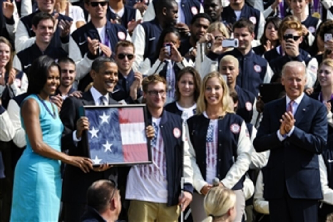President Barack Obama, second from left, is joined by First Lady Michelle Obama, far left, Paralympic swimmer Brad Snyder, center, Olympic fencer Mariel Zagunis, second from right, and Vice President Joe Biden during an event to honor members of the U.S. Olympic and Paralympic teams at the White House in Washington, D.C., Sept. 14, 2012. 