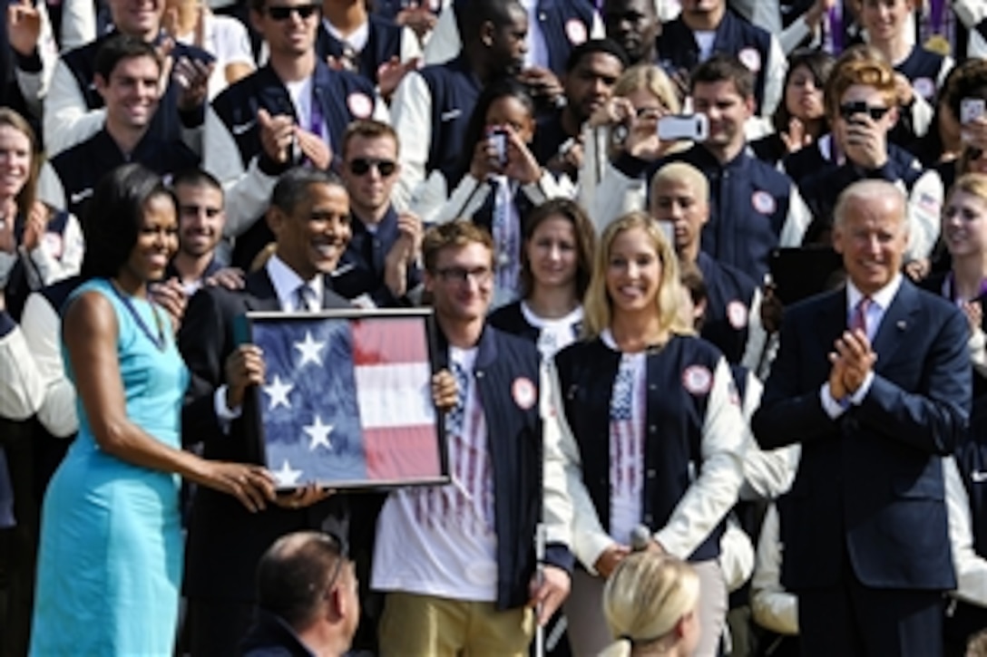 President Barack Obama, second from left, is joined by First Lady Michelle Obama, far left, Paralympic swimmer Brad Snyder, center, Olympic fencer Mariel Zagunis, second from right, and Vice President Joe Biden during an event to honor members of the U.S. Olympic and Paralympic teams at the White House in Washington, D.C., Sept. 14, 2012. 