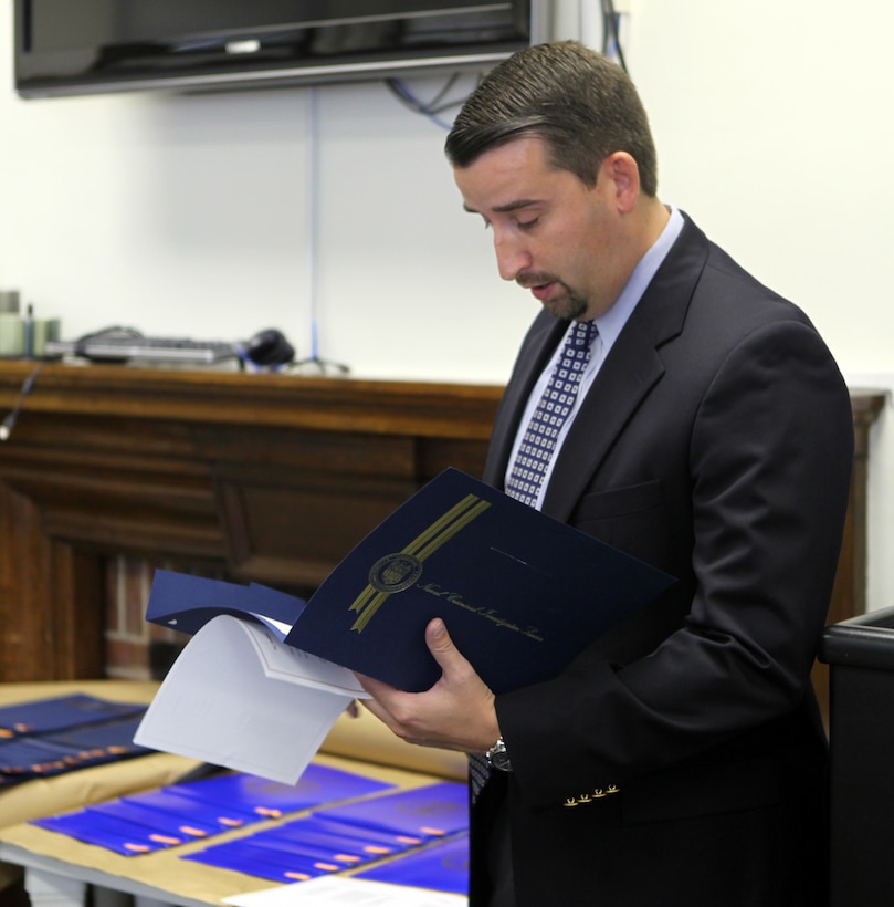 Supervisory Special Agent David Gardner reading aloud the operational excellence service award for the Provost Marshal Office special response team members aboard Marine Corps Base Camp Lejeune at Naval Criminal Investigation Service headquarters Aug. 31.  Kennedy spoke about a past experiance where SRT assisted NCIS.