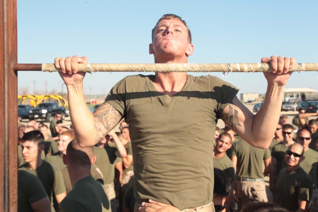Cpl. Joshua Pacheco, motor transport operator, 1st Tank Battalion, helps the Motor T Team in the pull-ups portion of 1st Tanks' field meet at Del Valle Field Aug. 31, 2012. The Motor T team went on to win the meet for the second time in a row.