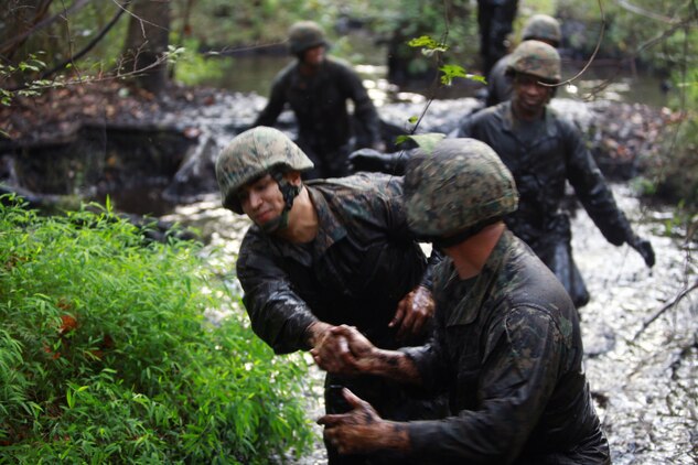 Marines and sailors with Landing Support Company, Combat Logistics Regiment 27, 2nd Marine Logistics Group help each other through the swamp during the endurance course at Battle Skills Training School aboard Camp Lejeune, N.C., Sept. 14, 2012. Servicemembers used teamwork to make sure no Marine was left behind.