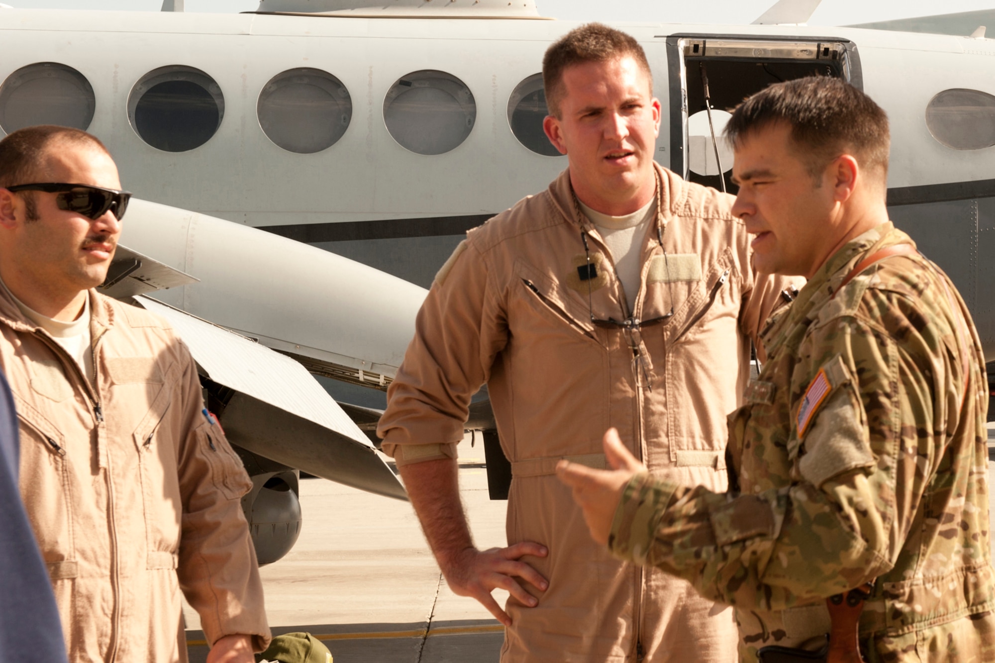 Lt. Col. Jeffrey Alexander (right), Commander 4th Expeditionary Reconnaissance Squadron, talks to crew members of an MC-12 Liberty after returning from a mission at Bagram Airfield, Afghanistan, September 11, 2012. The conclusion of this mission marks a milestone, as it signifies the 4 ERS officially exceeding over 100,000 flying hours using the MC-12s since the unit was stood up in Dec. 2009. 100,000 flying hours roughly equates to 11 and a-half years of flying for one the aircraft. 4 ERS leadership can say they accomplished this feat in under three years using its fleet of MC-12s. (U.S. Air Force photo/1st Lt. Marlene Solano)
