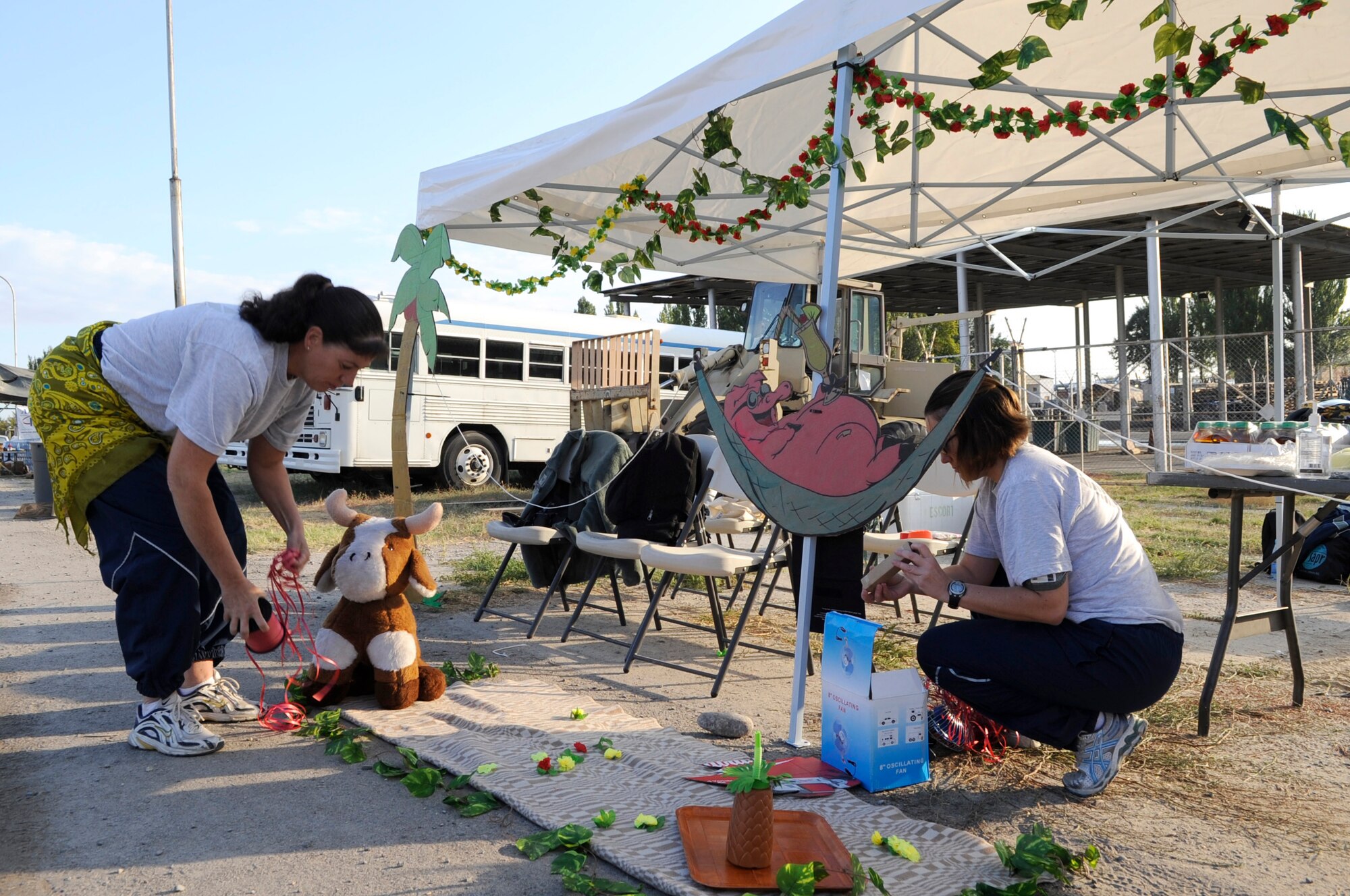 Tech. Sgt. Susanna Gyger and Staff Sgt Rebecca Kremer-Johnson put the finishing touches on a Hawaiian-themed water station during the U.S. Air Force Marathon at the Transit Center at Manas, Kyrgyzsatan, Sept. 15, 2012. Over 150 runners took part in one of three categories; 10K, half marathon and a 26.2 mile full marathon.  Gyger is a 376th Air Expeditionary Wing chaplain assistant deployed from Pennsylvania Air National Guard and a native of Hummelstown, Pa. Kremer-Johnson is a 376th Air Expeditionary Wing budget accounting technician deployed from Little Rock Air Force Base, Ark. Deployed locations like the Transit Center are known for hosting the Air Force Marathon to help build morale and promoting fitness among participants. (U.S. Air Force photo/Master Sgt. Jason Vaught)