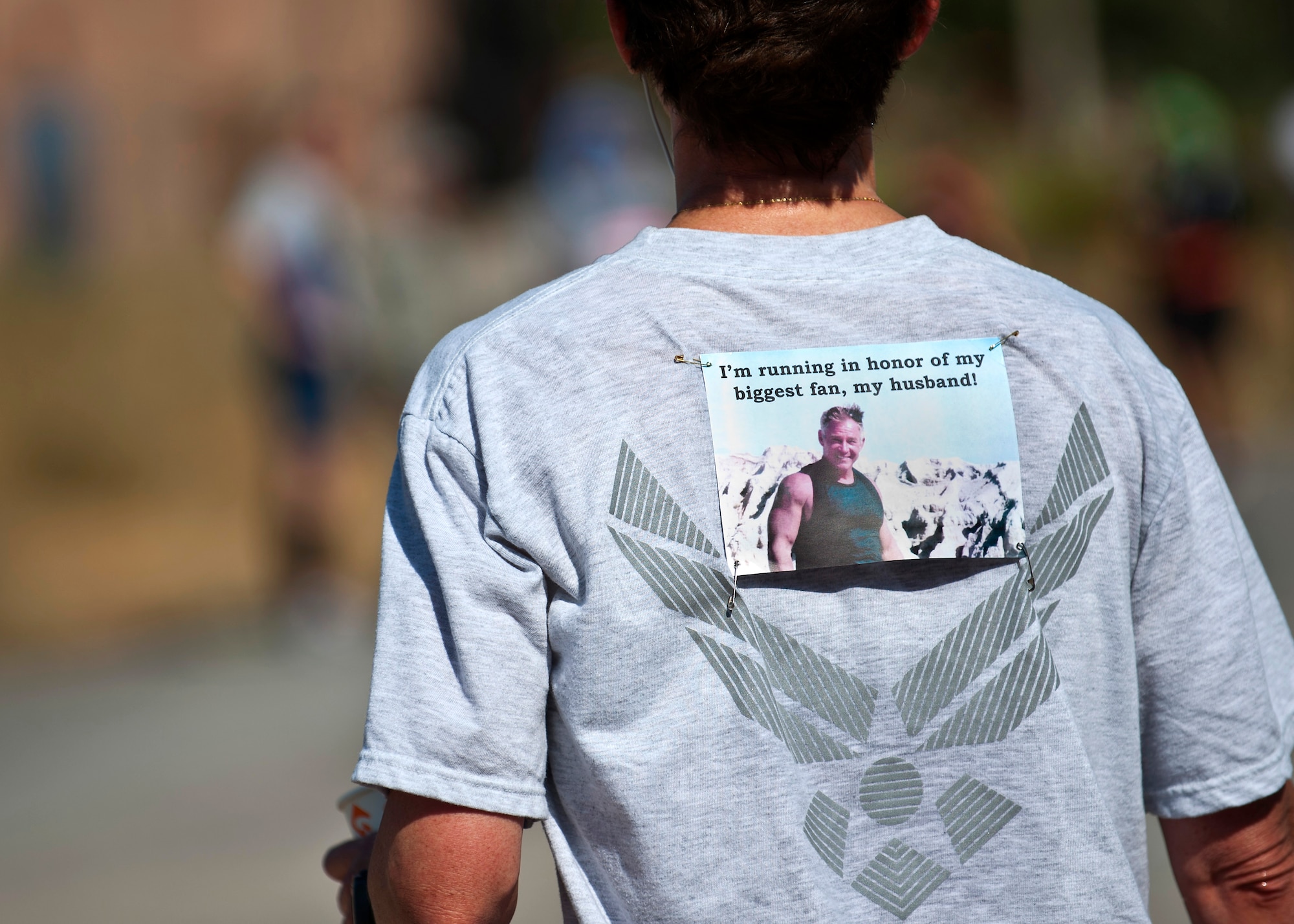 A photo of Lt. Col. Launa Bellucci's husband is pinned to her shirt during the Air Force Marathon at the Transit Center at Manas, Kyrgyzstan, Sept. 15, 2012. Bellucci was the first female to finish the full marathon with a time of 3:37:08. She is the 376th Expeditionary Mission Support Group deputy commander deployed from Ellsworth Air Force Base, S.D. (U.S. Air Force photo/Senior Airman Brett Clashman)