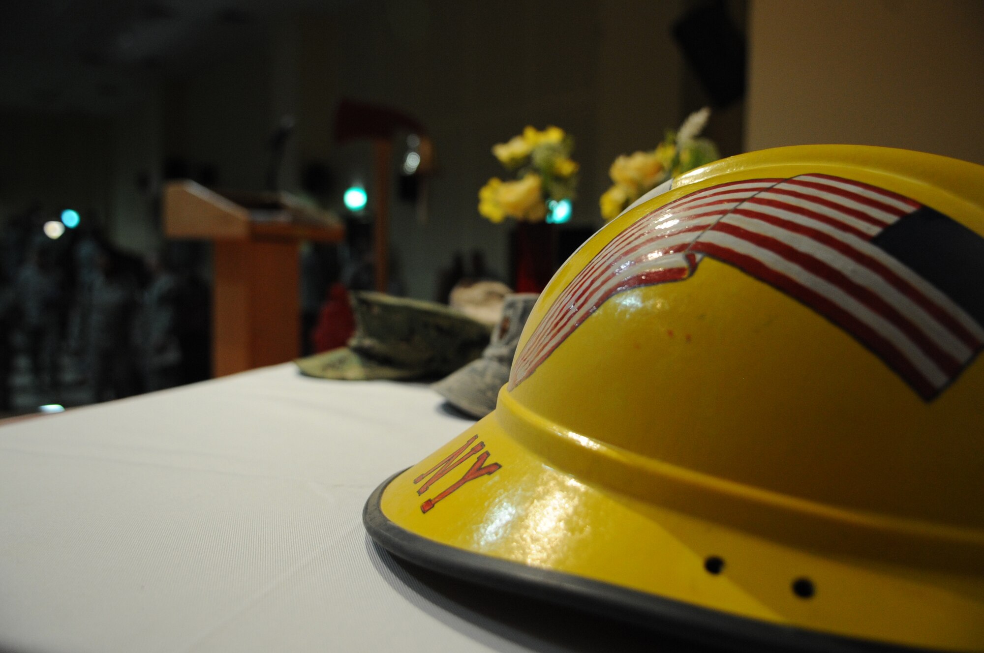 SOUTHWEST ASIA – Hats, helmets and other memorabilia are placed on a table on the stage of the Rock Theater for members of the 386th Air Expeditionary Wing to reminisce about the events that took place eleven years ago. (U.S. Air Force photo/Staff Sgt. Alexandra M. Boutte)