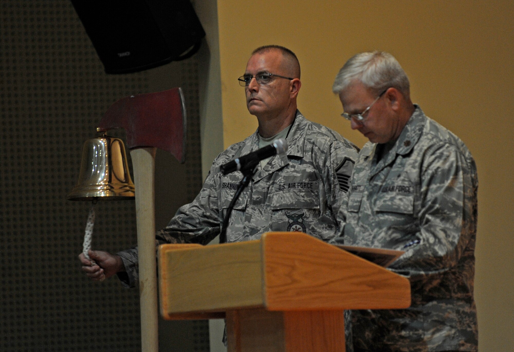 SOUTHWEST ASIA – Master Sgt. Gary Shannon, 386th Expeditionary Civil Engineer Squadron fire fighter, rings the bell as Ch. (Maj.) William Hoggatt addresses the eleven costs of freedom during the 9/11 Memorial Ceremony at the Rock Theater Sept. 11.  (U.S. Air Force photo/Staff Sgt. Alexandra M. Boutte)