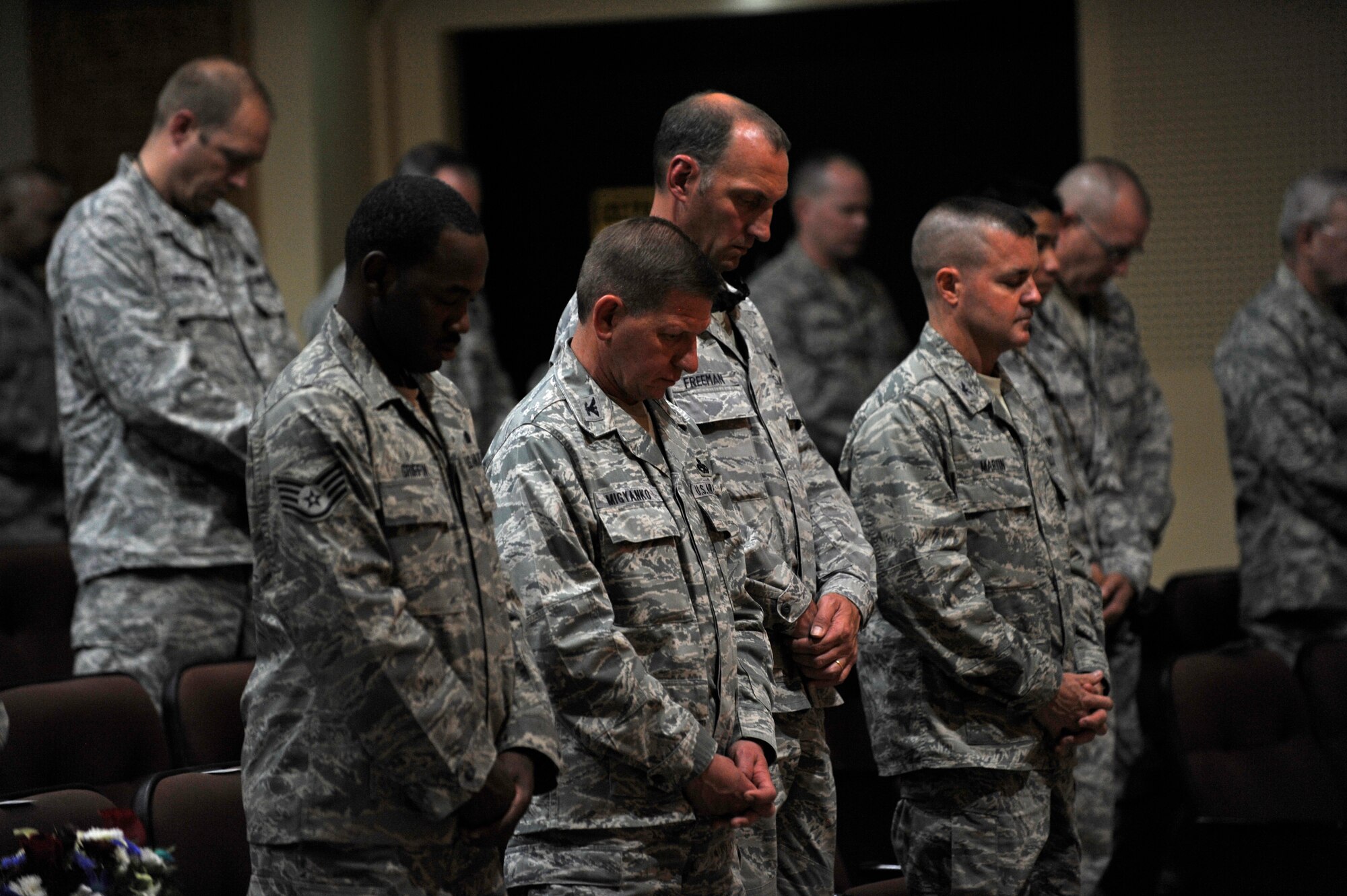 SOUTHWEST ASIA – Members of the 386th Air Expeditionary Wing bow their heads for a moment of silence during the 9/11 Memorial Ceremony at the Rock Theater Sept. 11. (U.S. Air Force photo/Staff Sgt. Alexandra M. Boutte)