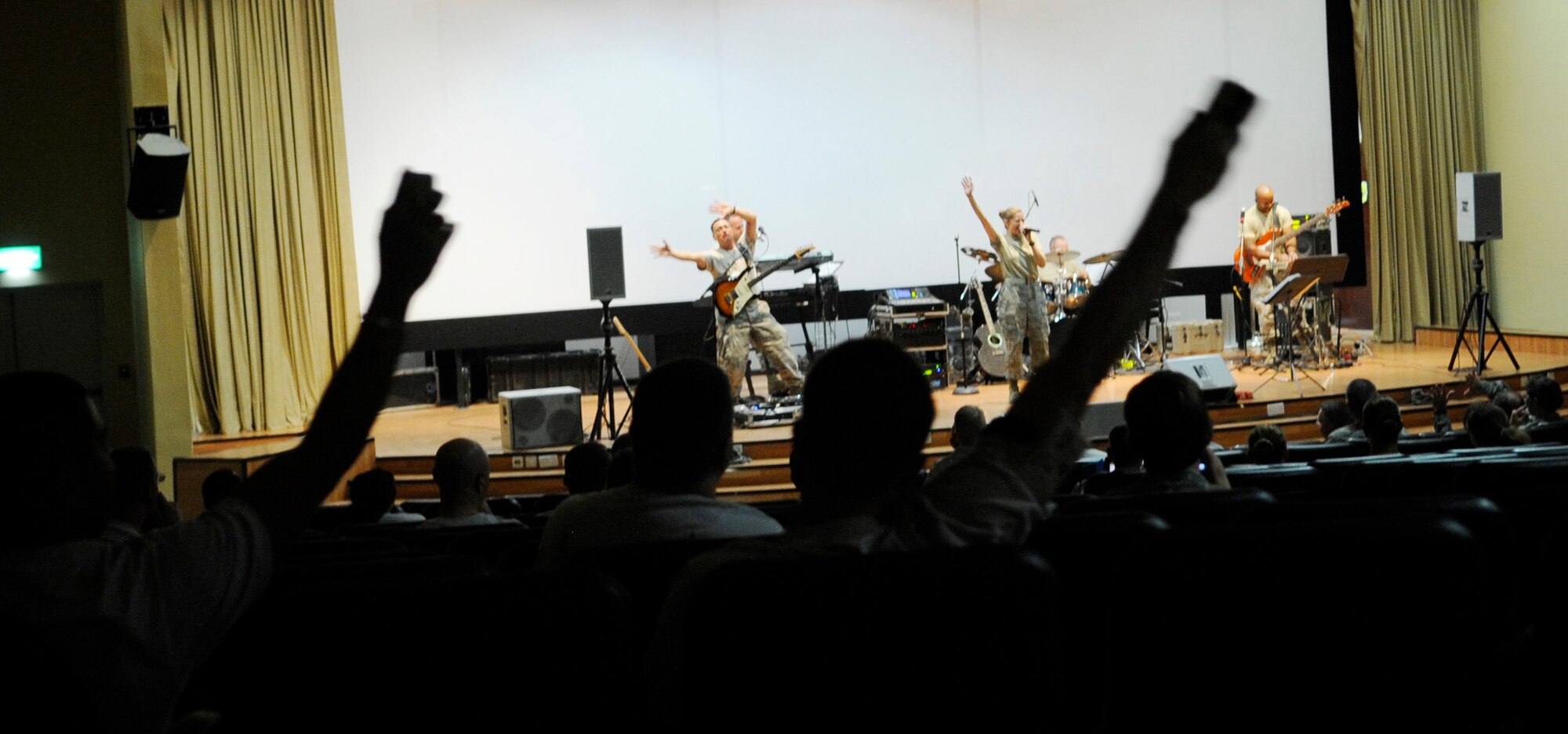 SOUTHWEST ASIA – Members of the 386th Air Expeditionary Wing wave their arms during the U.S. Air Forces Central Band Top Flight's performance of “We are Young” by fun. at the Rock Theater Sept. 8.  (U.S. Air Force photo/Staff Sgt. Alexandra M. Boutte)