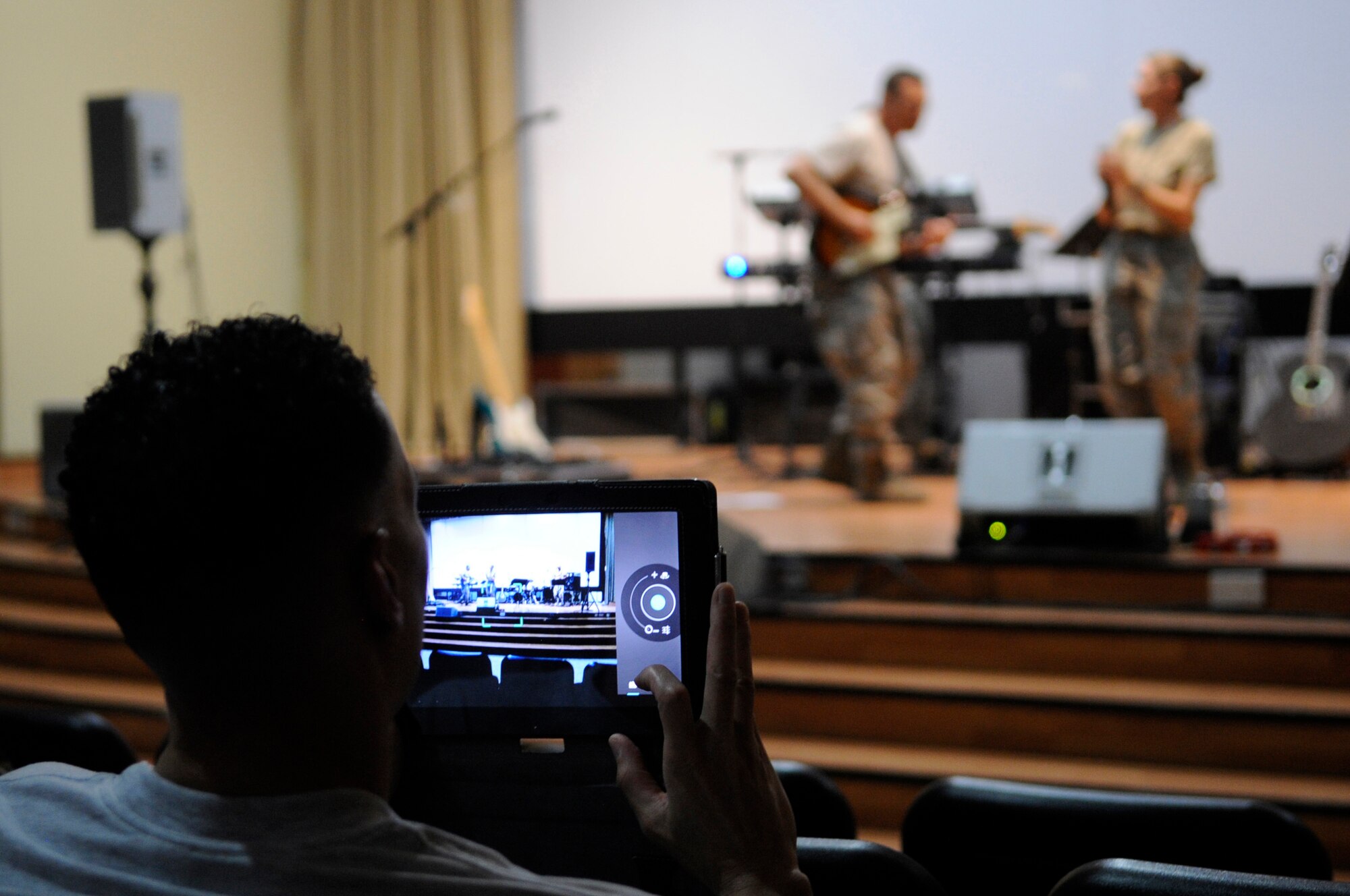 SOUTHWEST ASIA – Maj. Wayne Mosely, 386th Air Expeditionary Wing finance office, video records a performance from the U.S. Air Forces Central Band at the Rock Theater Sept. 8. The band rotates several ensembles through the AOR that perform a wide variety of musical styles to appeal to audiences of all ages and backgrounds. (U.S. Air Force photo/Staff Sgt. Alexandra M. Boutte)