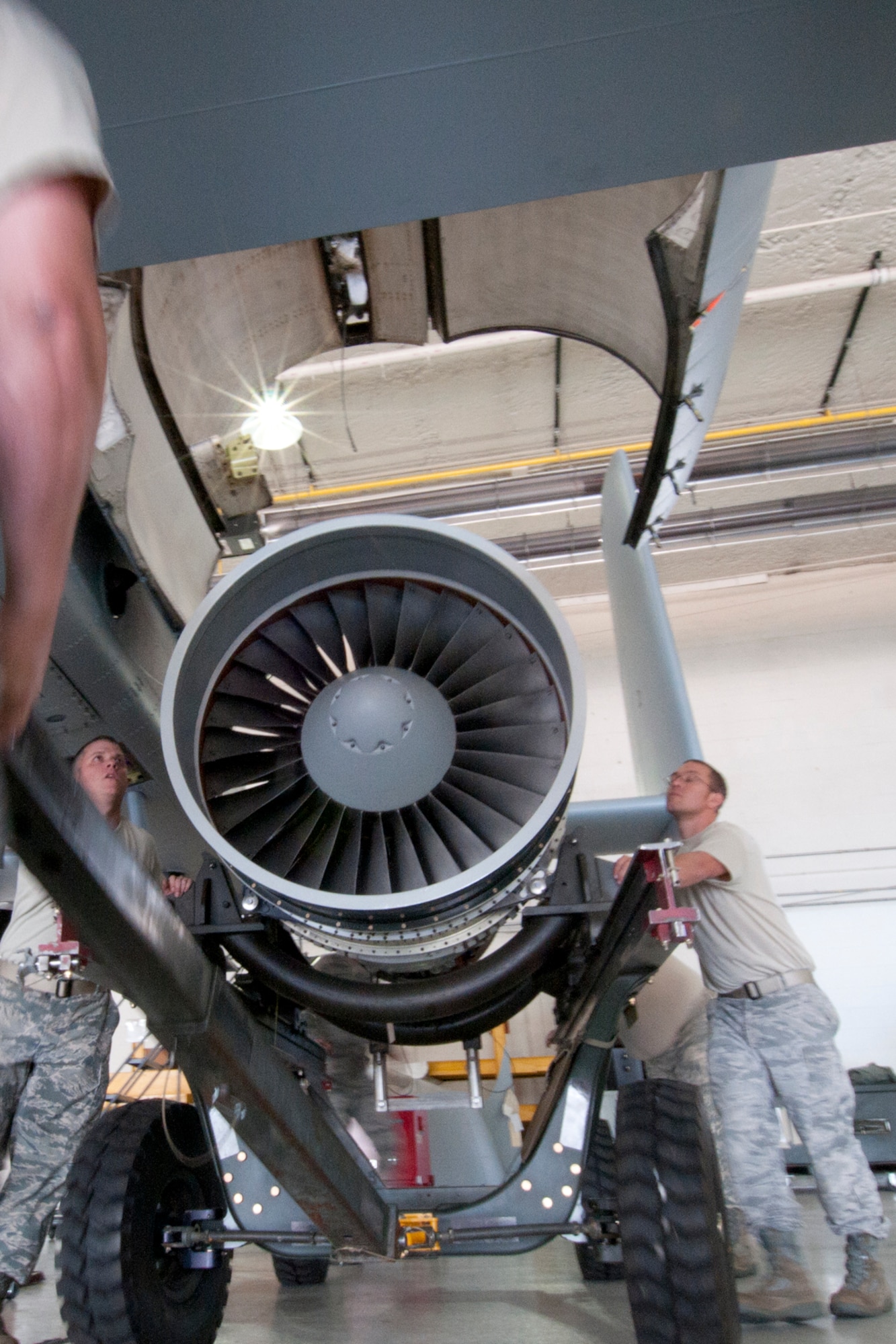 A group of Airmen from the 127th Maintenance Squadron work together to muscle an A-10 Thunderbolt II engine in to place as they prepare to load the engine on to the aircraft, Sept. 15, 2012, at Selfridge Air National Guard Base, Mich. The engines can be removed from the frame of the aircraft to allow maintenance to be performed on the engine. (Air National Guard photo by TSgt. Robert Hanet)
