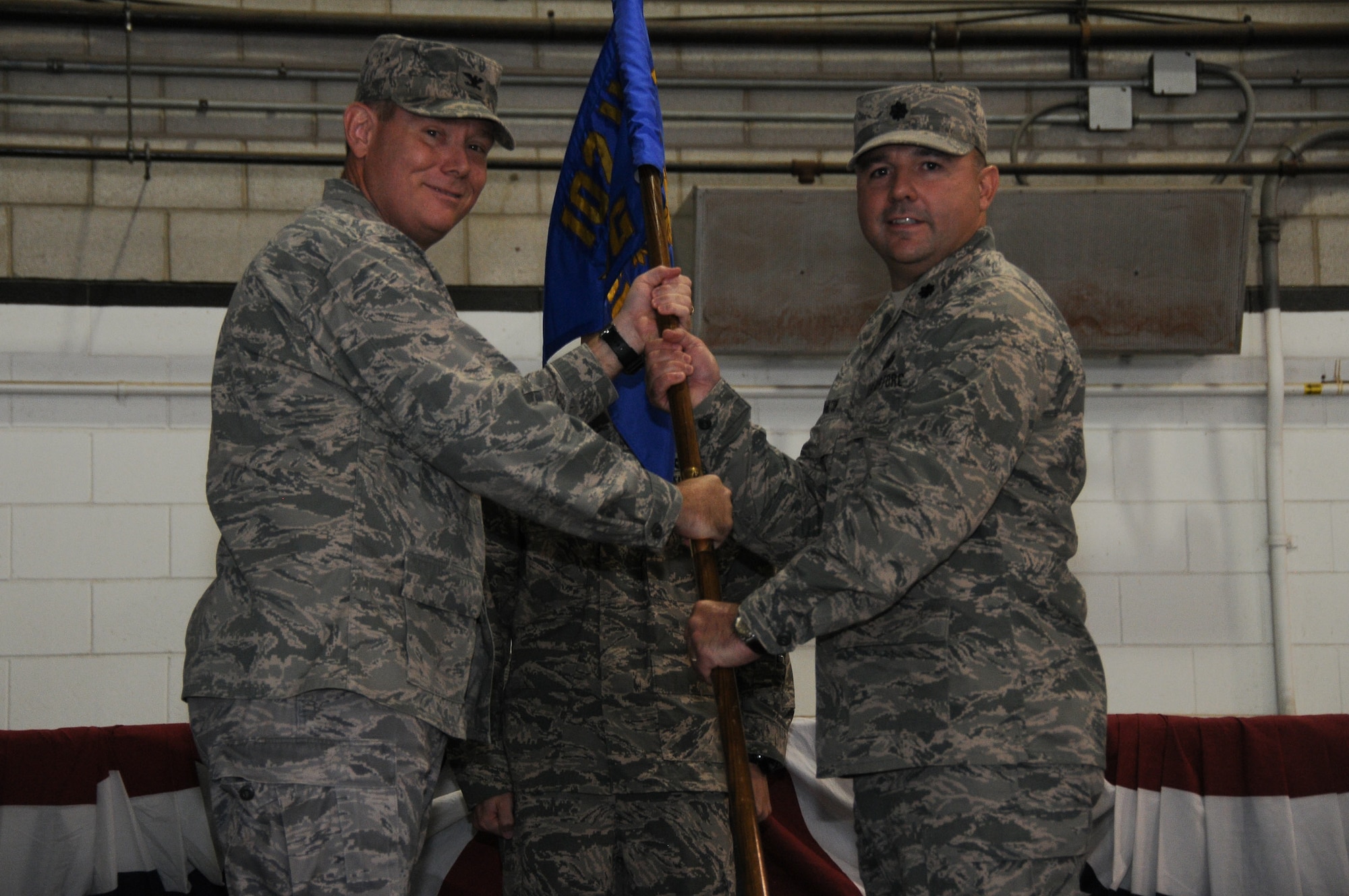 Col. Patrick J. Cobb, 102nd Intelligence Wing commander, passes the 102nd Mission Support Group flag to Lt. Col. Christopher Hamilton during a change of command ceremony at Otis Air National Guard Base, Mass., Sept. 15, 2012. Hamilton's previous assignment was 102nd Security Forces Squadron commander. (Air National Guard photo by Senior Airman Patrick McKenna/Released)