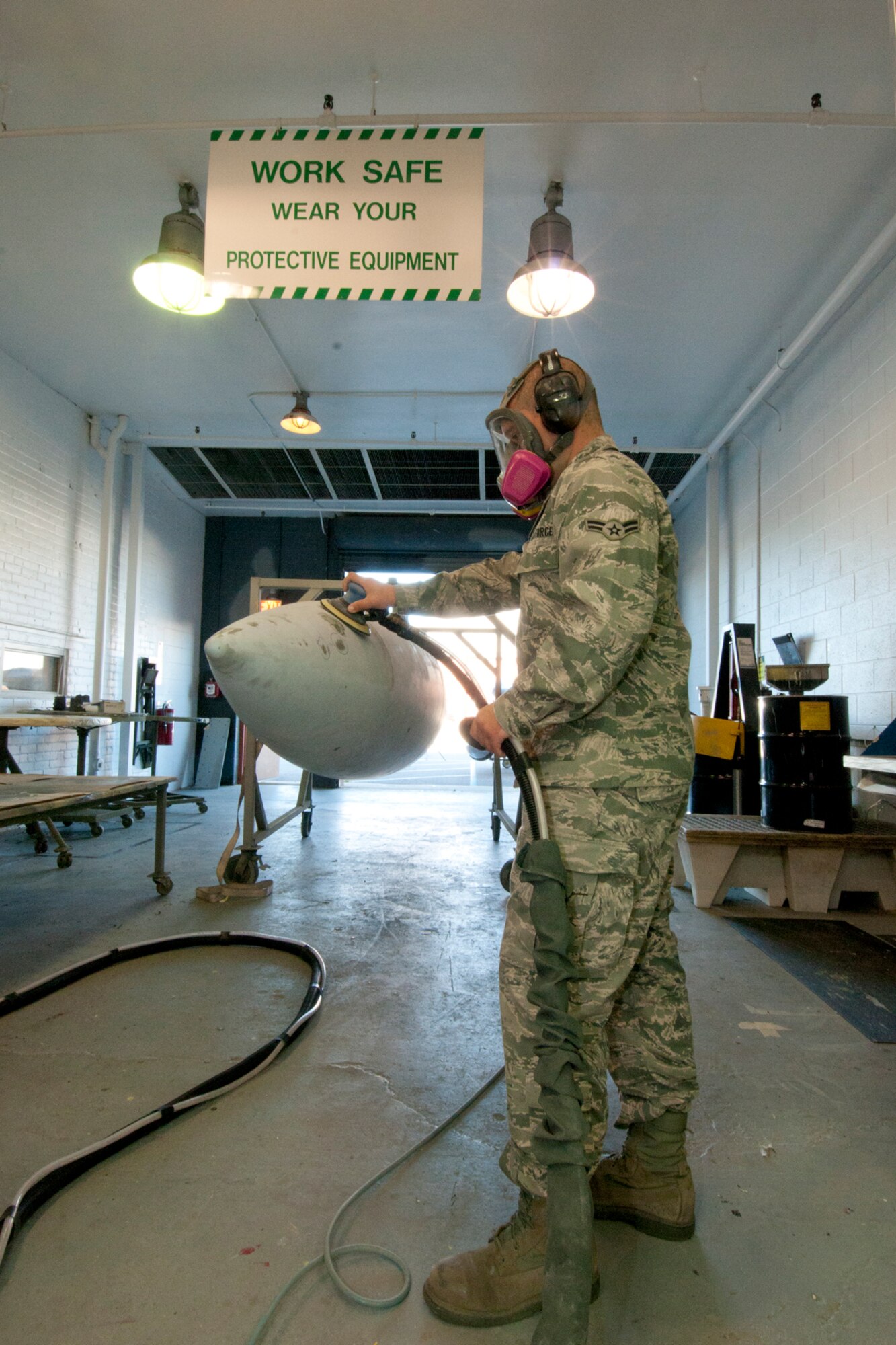 Airman 1st Class Dan Butcher uses a sander to prepare a centerline tank for a fresh coat of paint, while working in the painting bay of the 127th Maintenance Squadron at Selfridge Air National Guard Base, Mich., Sept. 15, 2012. The sander has a vacuum attachment to control dust. While maintenance Airmen at the base said the paint on an aircraft plays a major role in corrosion control and has other benefits, they also take a great deal of pride in the appearance of the aircraft they maintain.  The centerline tank is used by A-10 Thunderbolt II aircraft assigned to the base as an additional, external fuel tank when the aircraft must make long treks, such as a trip overseas. (Air National Guard photo by TSgt. Robert Hanet)