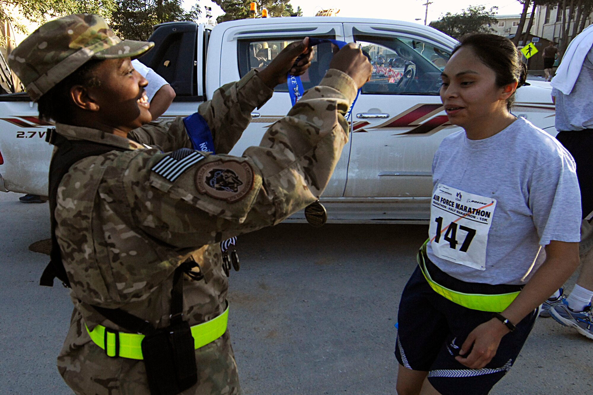 MSgt Elaine Thompson, 4th Expeditionary Reconnaissance Squadron first sergeant, presents a medal to SSgt Janet Gonzalez, 4 ERS, after she completed the Air Force Marathon (Bagram) at Bagram Airfield, Afghanistan, Sept. 15, 2012. More than 500 people registered to run. Runners chose from four distances; the full-marathon, the half-marathon, a ten-kilometer run, or a five-kilometer run. Bagram was one of seven deployed locations throughout the area of responsibility that participated in the Marathon. (U.S. Air Force photo/SSgt Jeff Nevison)