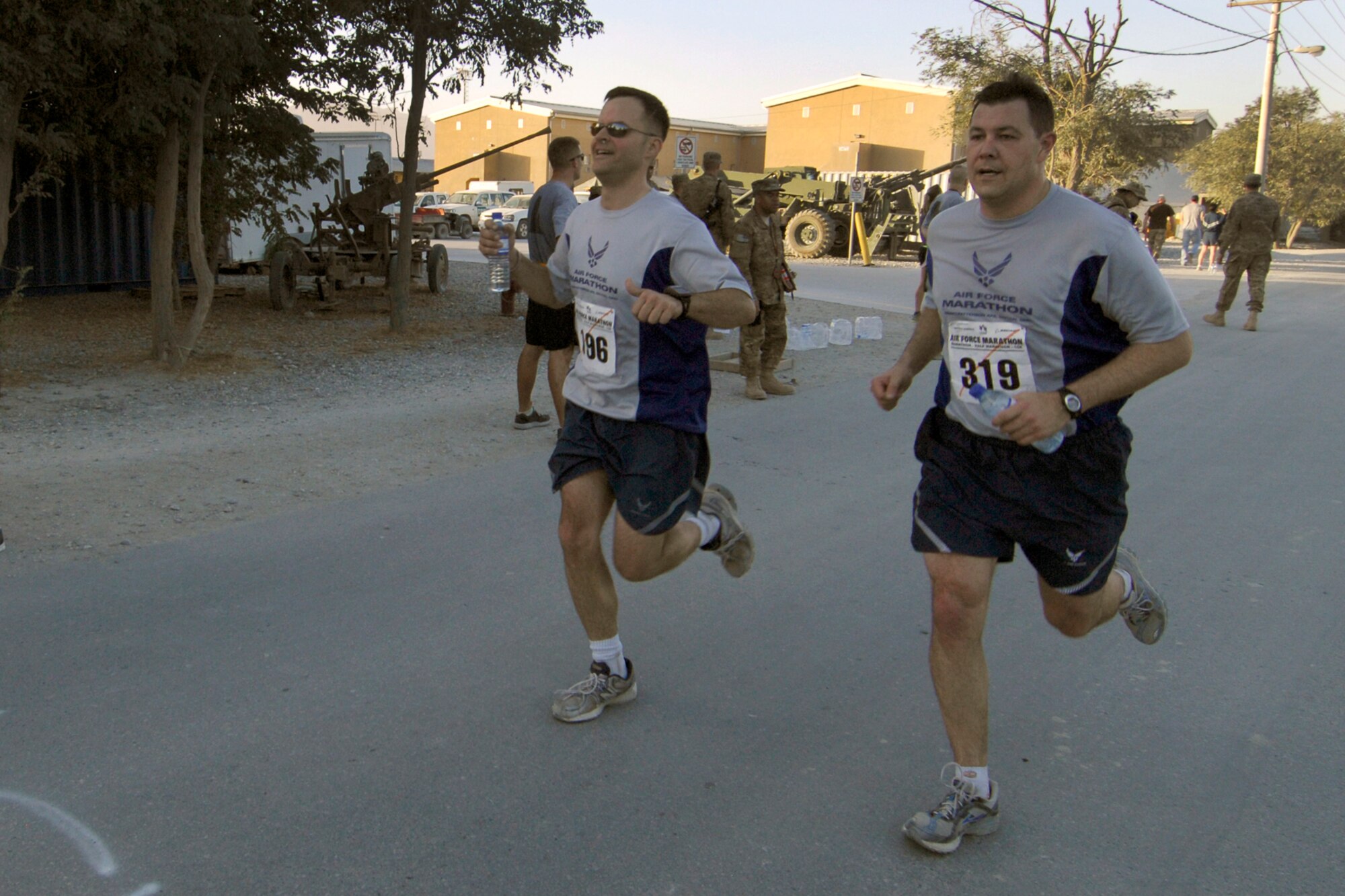 Two Airmen assigned to the 455th Air Expeditionary Wing finish the U.S. Air Force Marathon (Bagram) at Bagram Airfield, Afghanistan, Sept. 15, 2012. More than 500 people registered to run. Runners chose from four distances; the full-marathon, the half-marathon, a ten-kilometer run, or a five-kilometer run. Bagram was one of seven deployed locations throughout the area of responsibility that participated in the Marathon. (U.S. Air Force photo/SSgt Jeff Nevison)