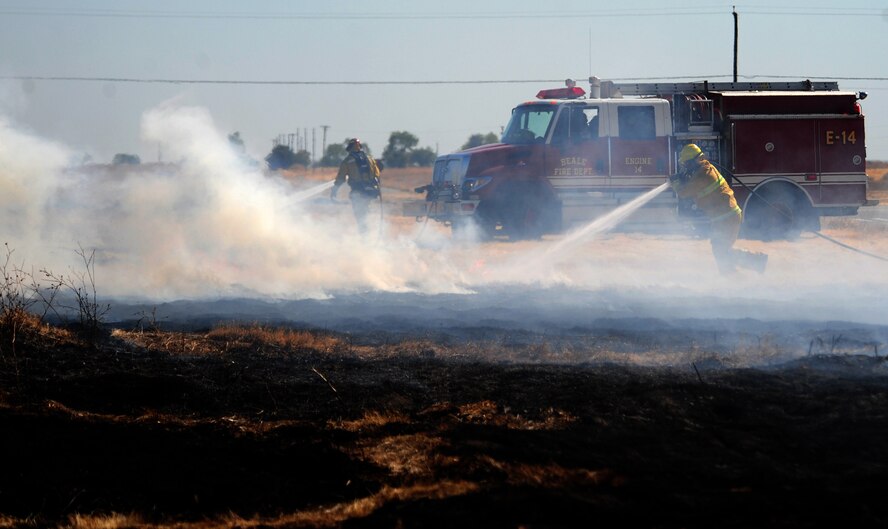 U.S. Air Force firefighters extinguish the remnants of a grass fire at Beale Air Force Base, Calif. Sept. 13, 2012. The blaze consumed approximately 17 acres. (U.S. Air Force photo by Senior Airman Shawn Nickel/Released)