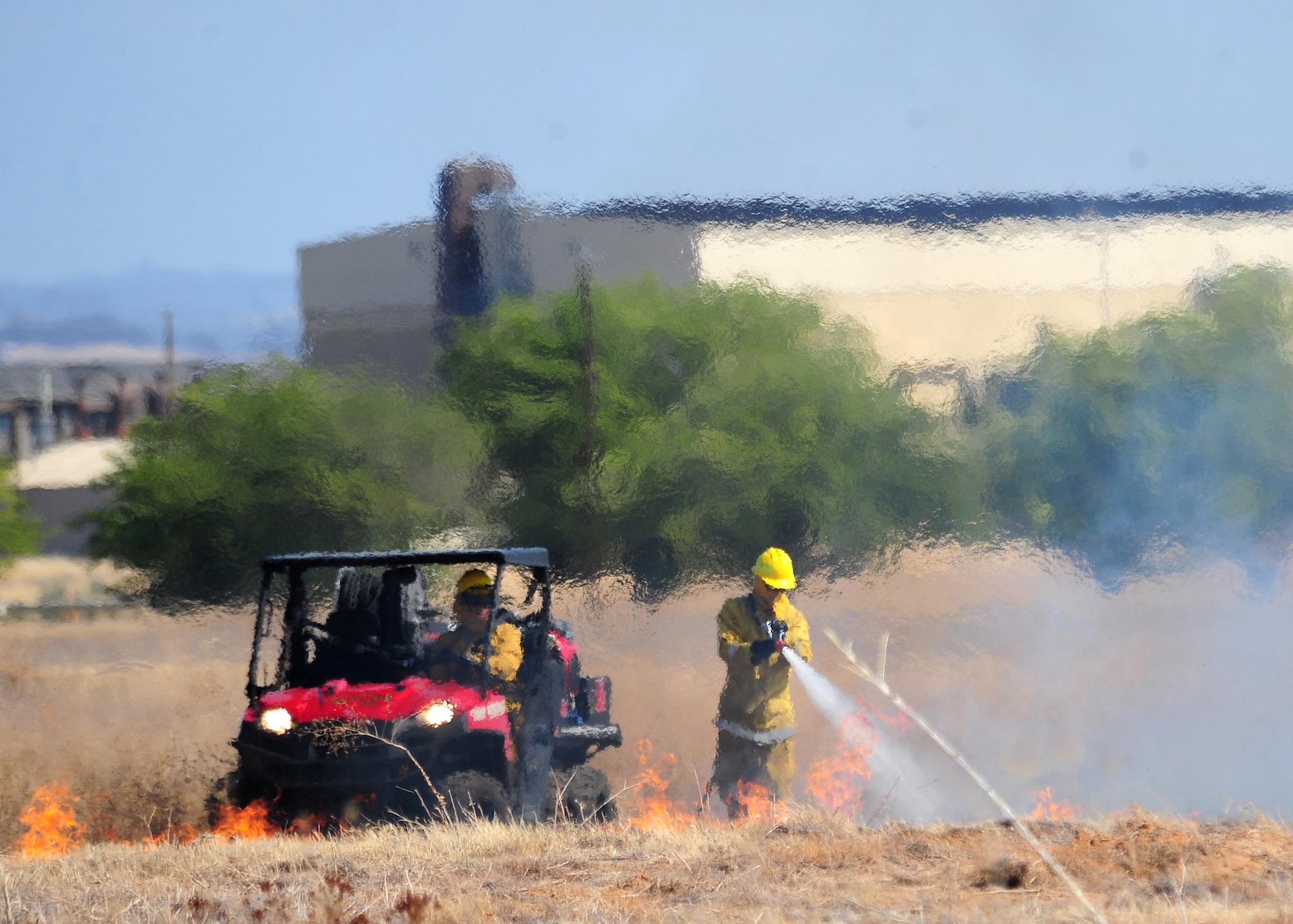 U.S. Air Force firefighters utilize a "Scout" vehicle to battle a brush fire at Beale Air Force Base, Calif., Sept. 13, 2012. The scout is an all terrain vehicle equipped with fire fighting capabilities. (U.S. Air Force photo by Senior Airman Shawn Nickel/Released)